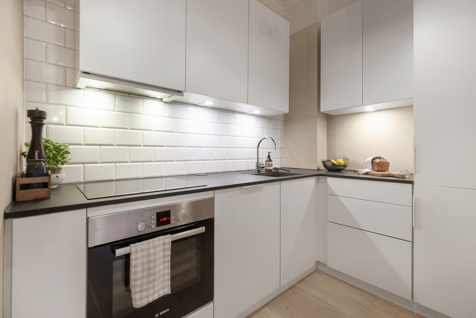 Lys innredning med laminat benkeplate og metrofliser over benkeplaten. Galleribilde