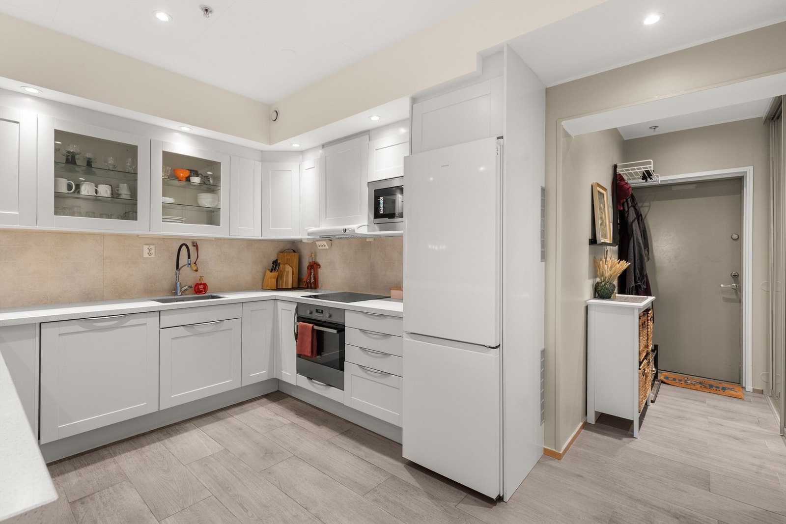 Stilren HTH kjøkkeninnredning med profilerte fronter og benkeplate av stein med underlimt vaskekum. Galleribilde