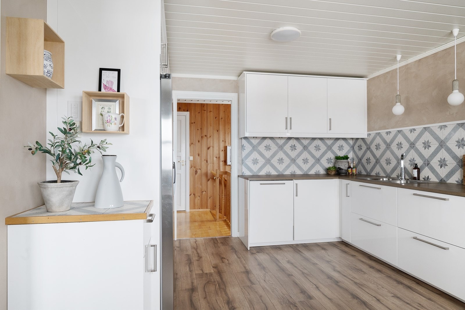 Flislagt bakvegg med geometrisk mønster gir kjøkkenet et dekorativt preg. Galleribilde