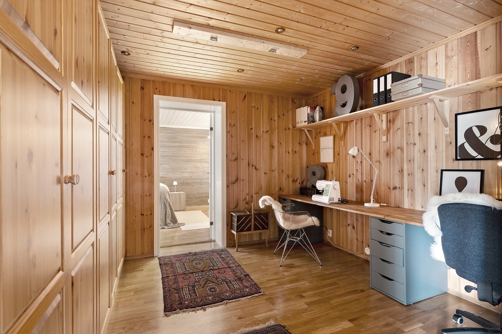 Panelvegger og tak i tre gir en varm og naturlig følelse, med oppbevaring som effektivt utnytter plassen. Galleribilde