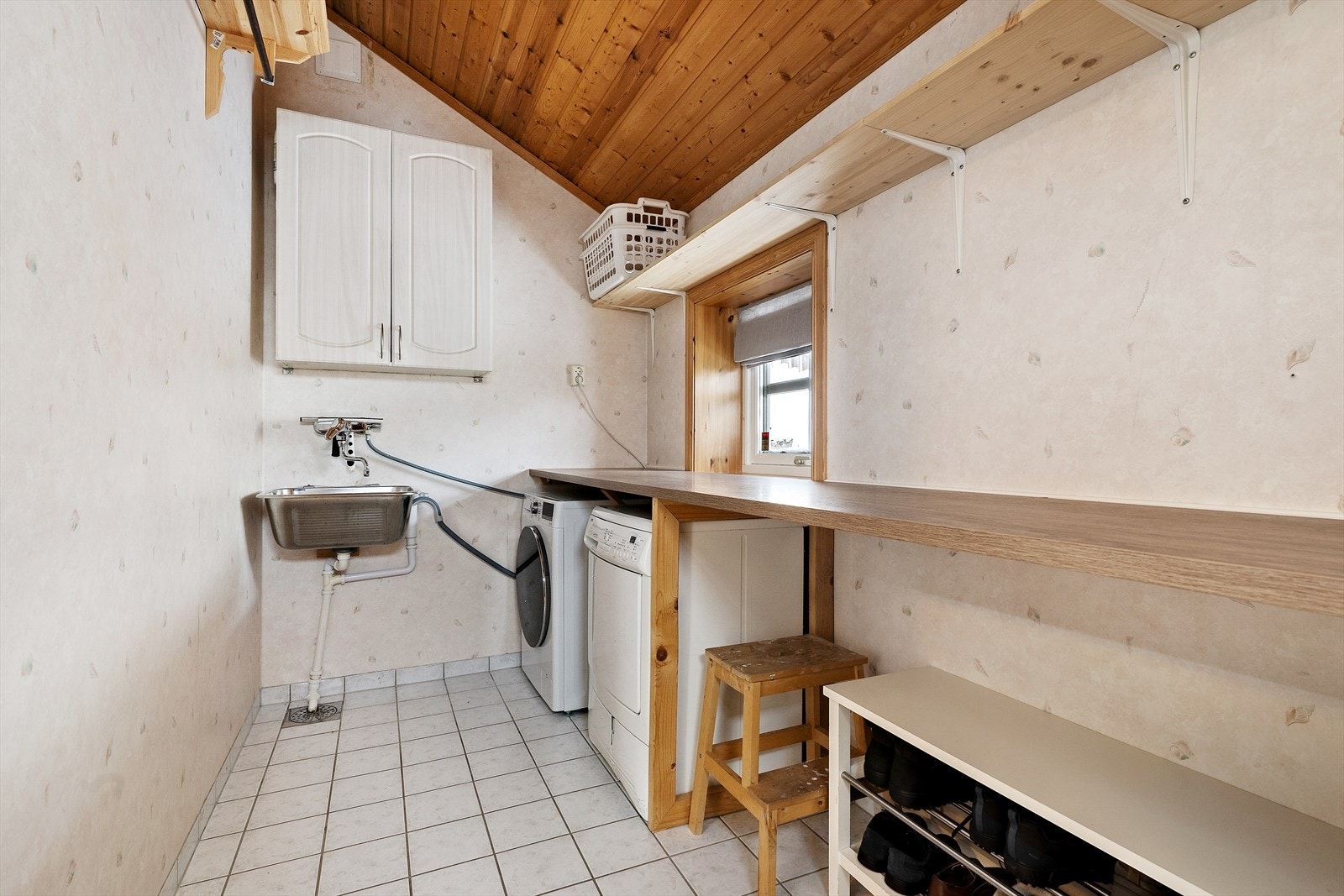 Vaskerommet har flislagt gulv og opplegg for vaskemaskin, samt utslagsvask med benkplass. Veggene er kledd med tapet og sokkelflis, og himlingen er av ubehandlet trepanel Galleribilde