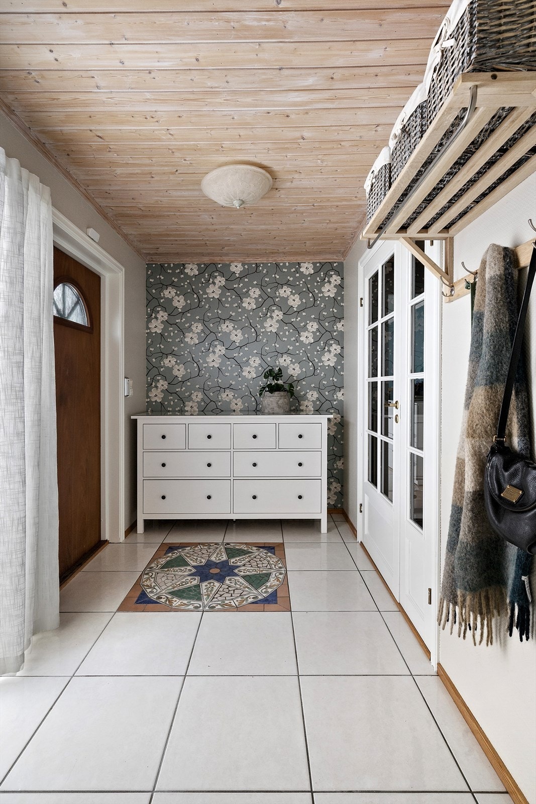 Lys og praktisk entre med flislagt gulv og god oppbevaringsplass. Galleribilde