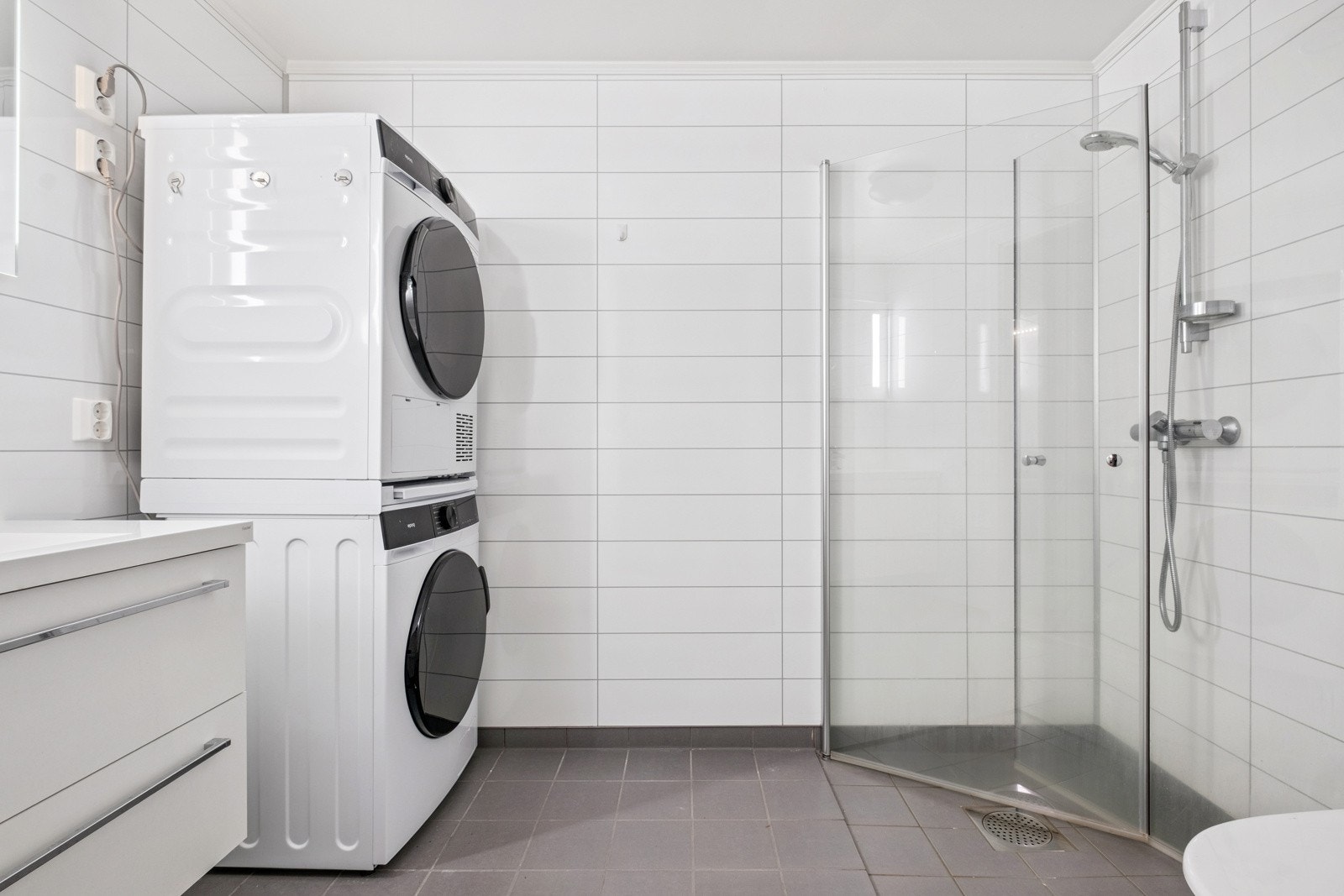 Romslig og moderne bad med flislagte overflater og funksjonell innredning. Galleribilde