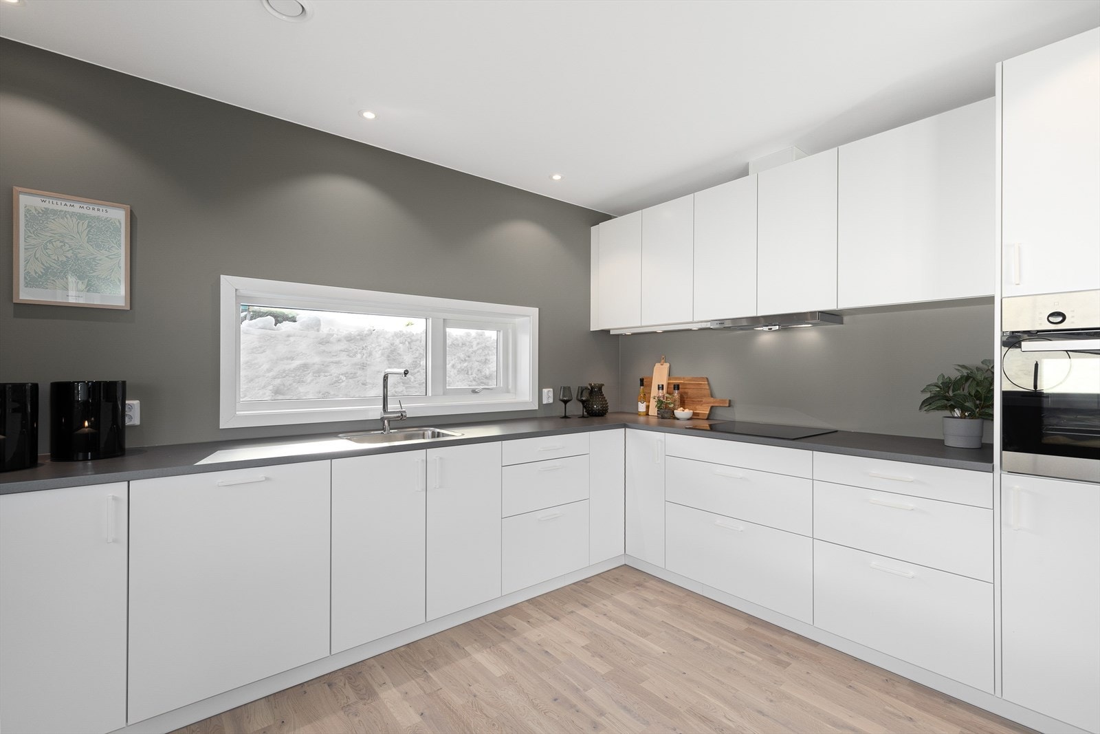 Kjøkkenet har en praktisk L-form med rikelig benke- og skapplass. Galleribilde