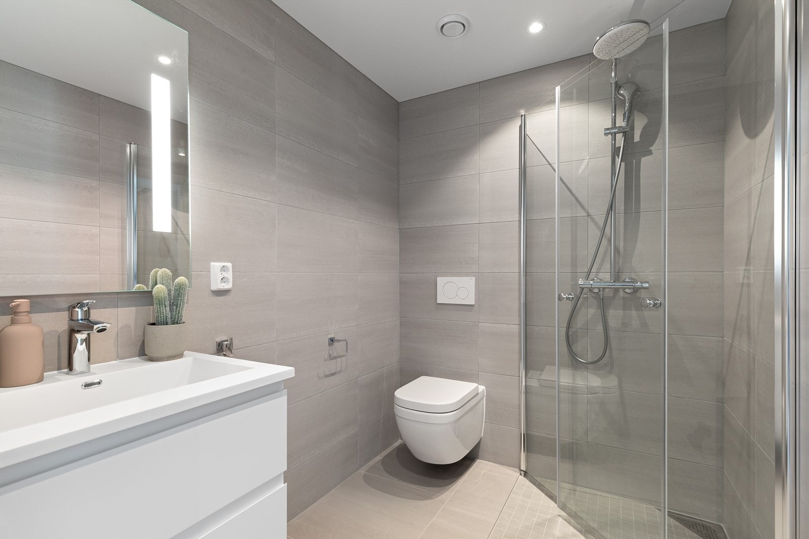 Badet i første etasje er helfliset med vegghengt toalett, servantinnredning og dusjhjørne. Galleribilde