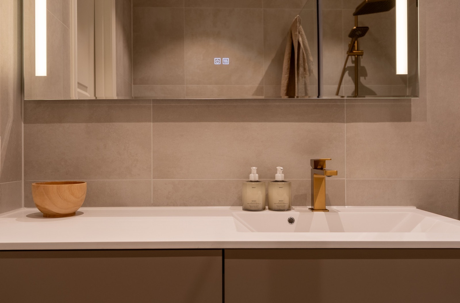 Badet er innredet med vegghengt servantinnredning med ovenpåliggende servant, samt speil med belysning og stikkontakt. Galleribilde