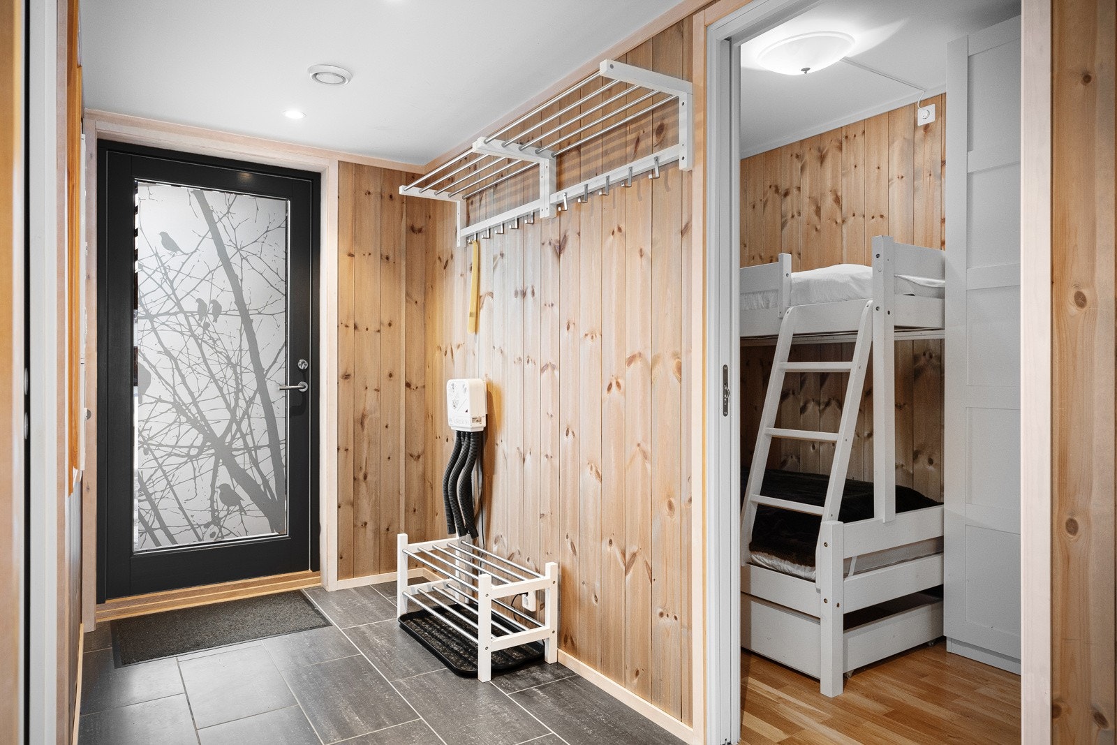 Hyggelig entré med flislagt gulv og plass til å henge fra seg yttertøy og sko. Galleribilde