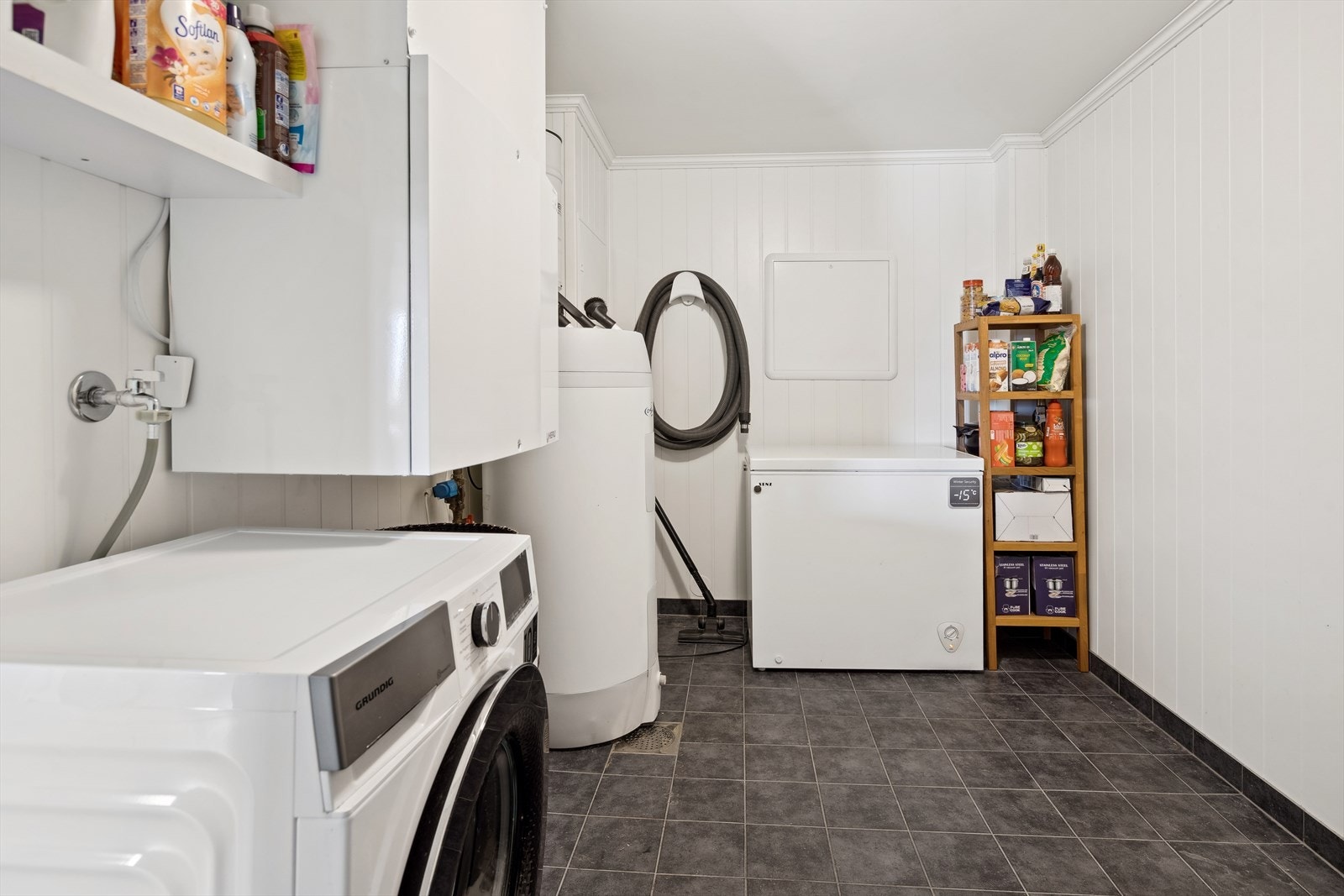 Vaskerommet har flislagt gulv med elektriske varmekabler og mdf-plater på veggene. Vaskerommet er innredet med sentralstøvsuger, ventilasjonsaggregat, vv-bereder, sikring- og nettskap, vannfordelingsskap og opplegg for vaskemaskin og tørketrommel. Galleribilde