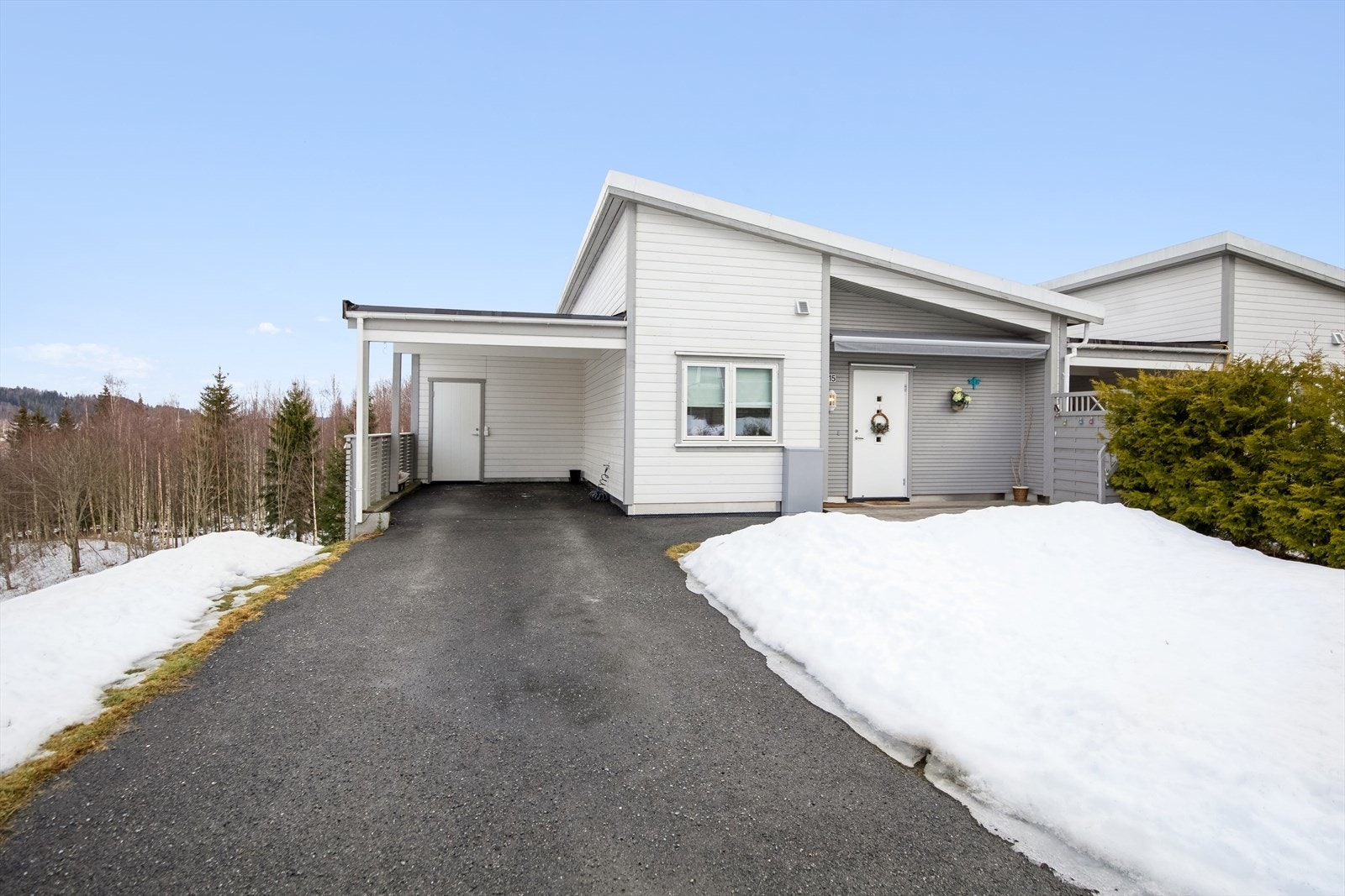 Gruset innkjøring og carport. Andelen har ansvar for hageflekken utenfor inngangspartiet. Galleribilde