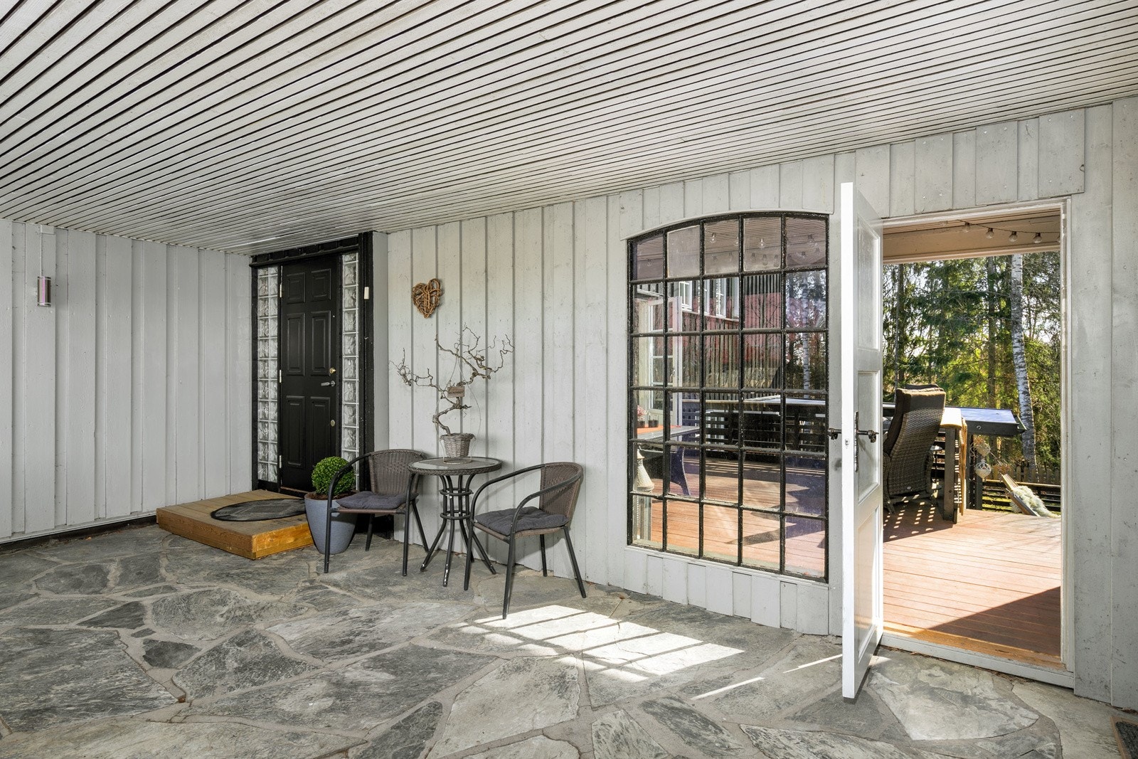 Representativt inngangsparti med skiferheller. Eier har fått etablert egen inngang med dør og flott smijernsvindu, for passasje direkte til uteplassen på 20 kvm. Galleribilde