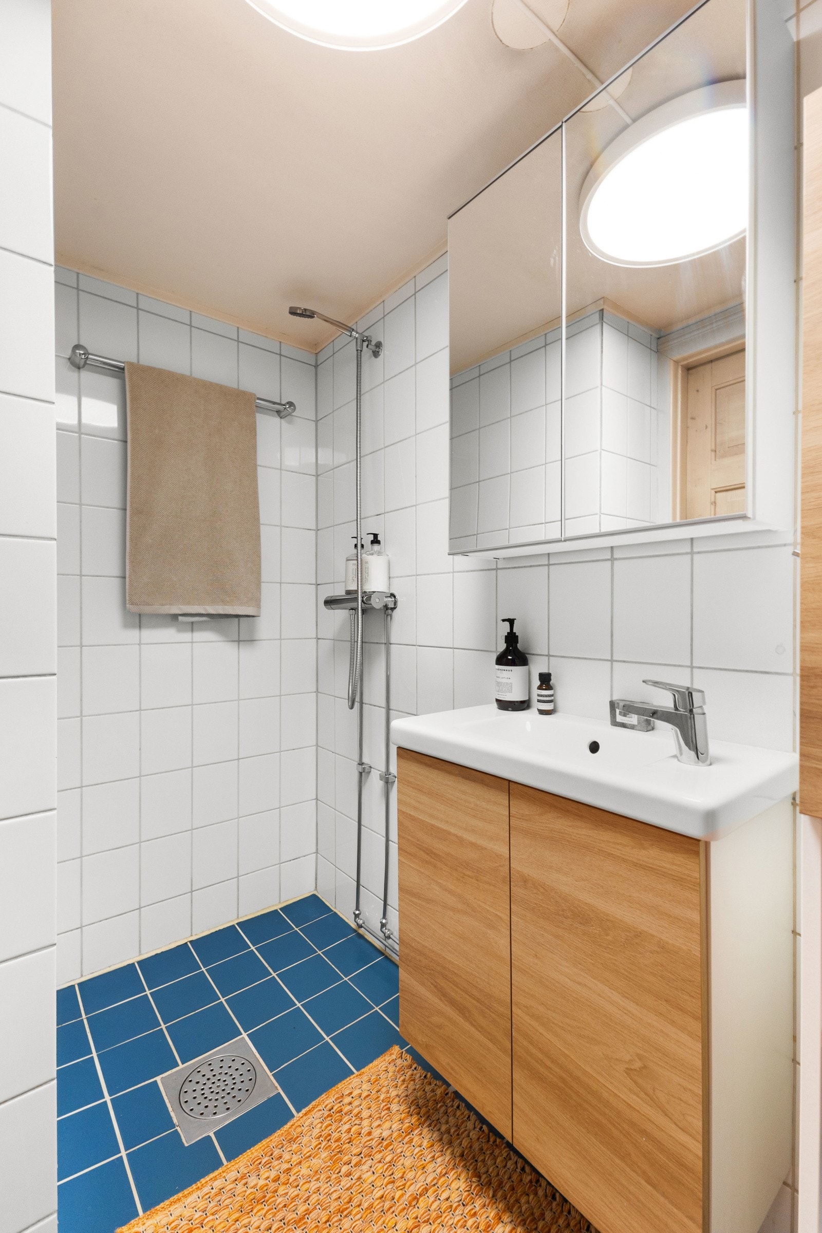 Det flislagte badet er utstyrt med dusjsone, servant og WC. Galleribilde