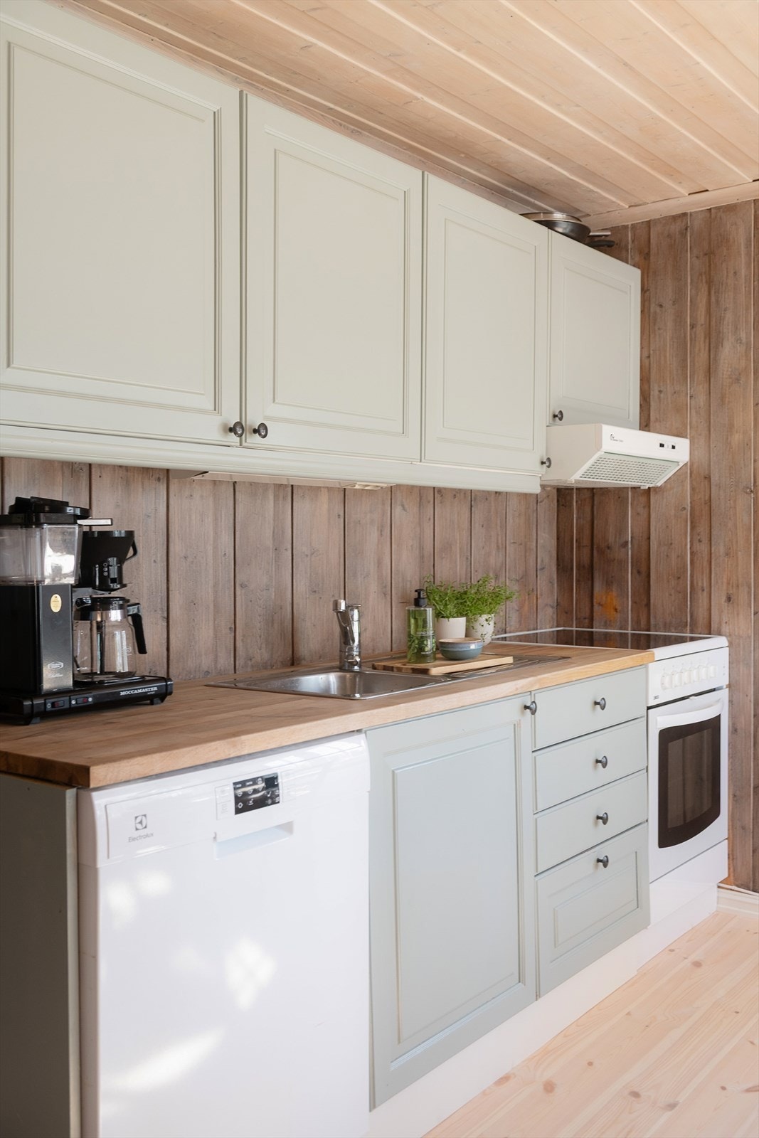 Moderne og praktisk kjøkken med lysegrå fronter med enkel profilering. Plass til komfyr og oppvaskmaskin. Galleribilde