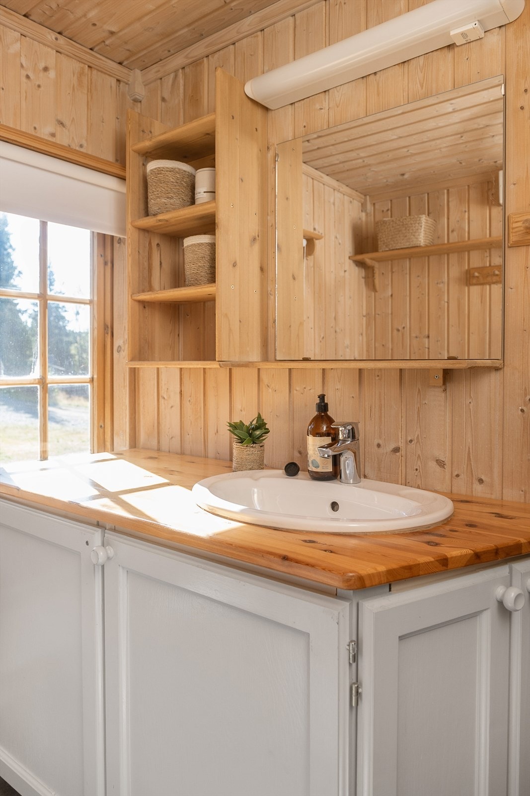 Baderomsinnrendingen har fronter malt i en delikat gråtone med enkel profilering. Skap for oppbevaring. Galleribilde