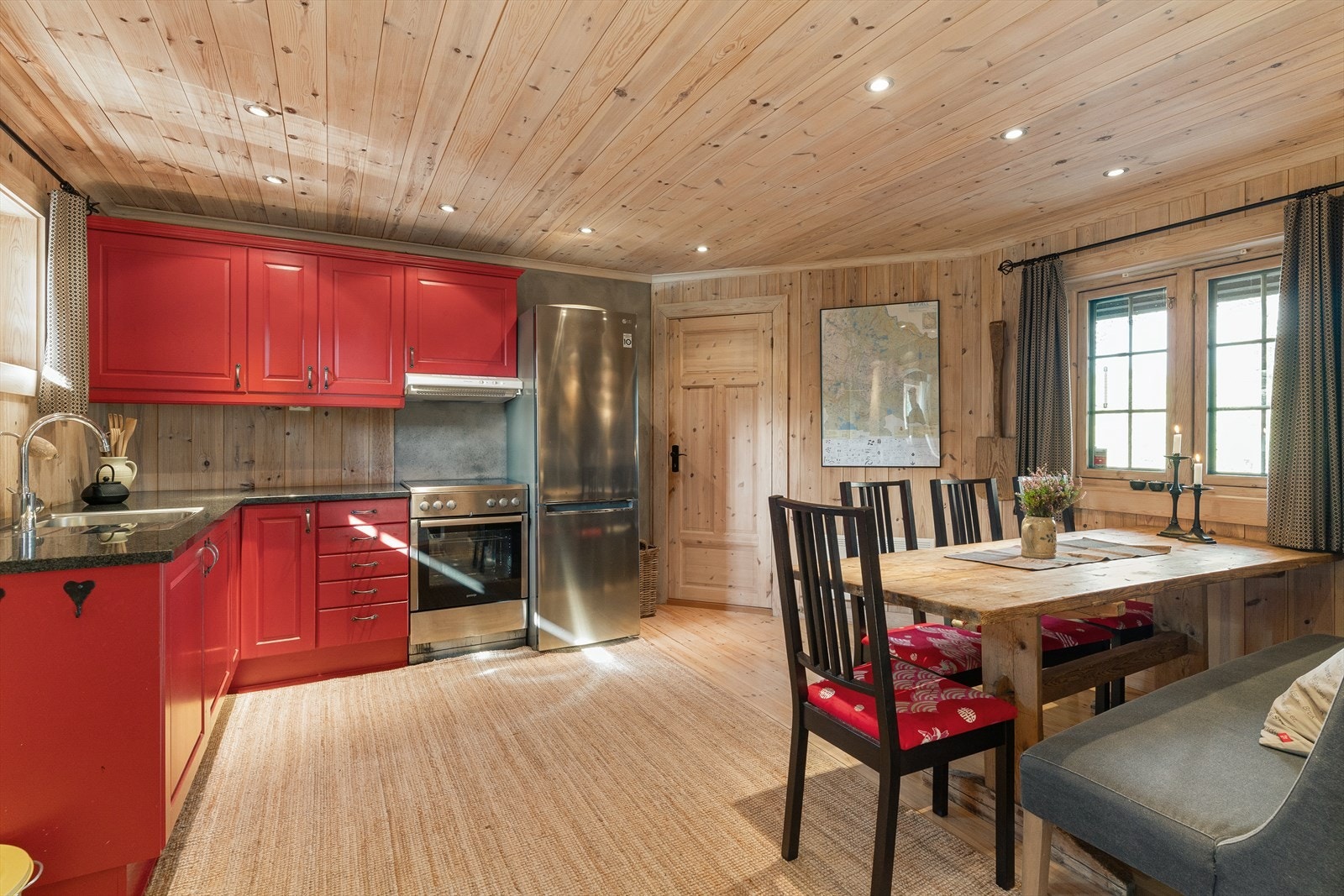 Kjøkkenet har innredning med profilerte fronter og benkeplate av stein. Galleribilde