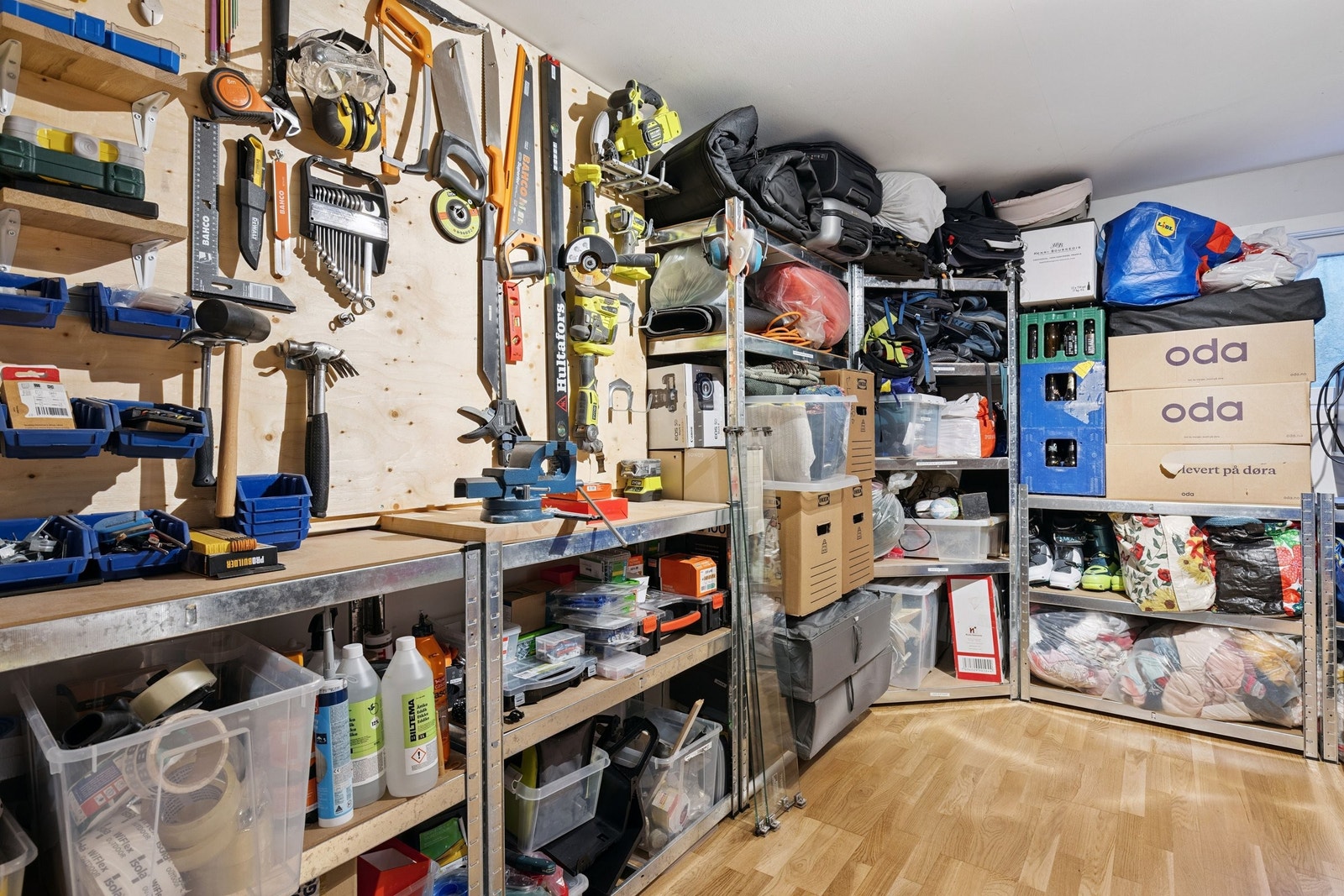 Stor innvendig bod på 12.5 kvm med fastmontert hylleløsning på 3 av 4 vegger og praktisk verktøystasjon. Kan ved enkle modifikasjoner (fastmontert kasse mot vegg) få godkjent rømningsvei også fra dette rommet. Galleribilde