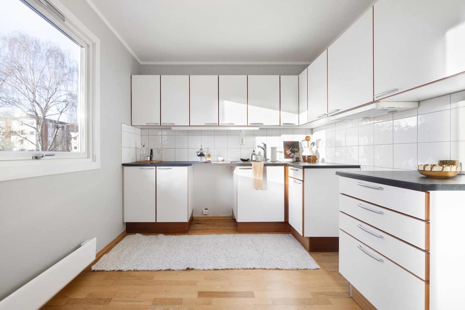 Kjøkken fra 2008 med glatte fronter, laminert benkeplate med oppvaskkum i rustfritt stål med svingbart blandebatteri. Galleribilde