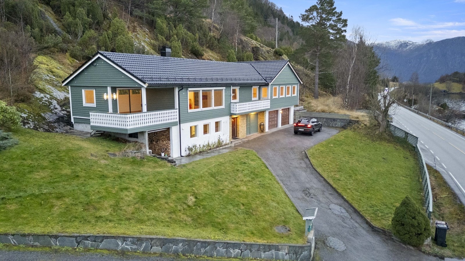 Asfaltert oppkjørsel og tunplass fremfor inngangspartiet og garasje Galleribilde