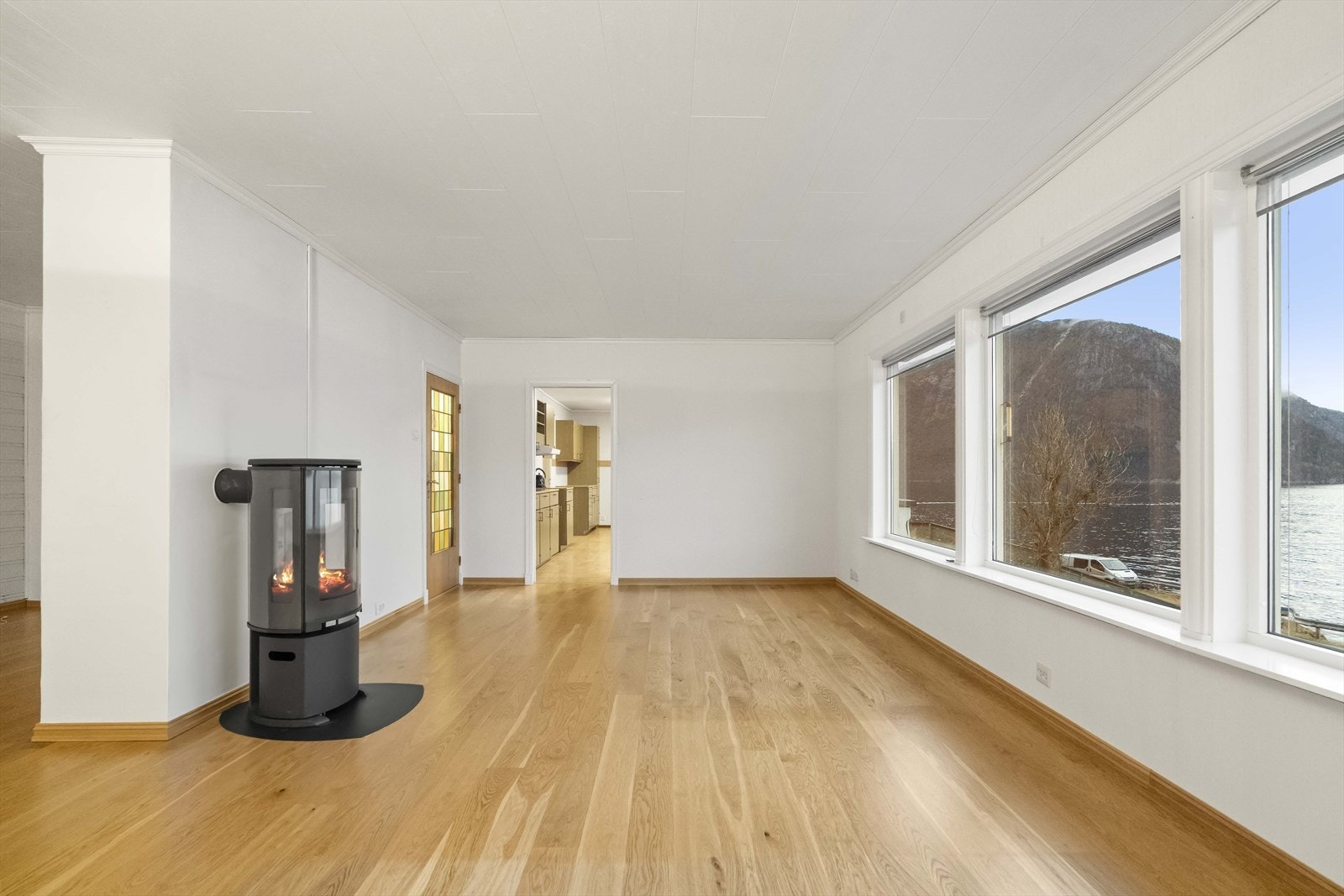 Stova har lysmalte overflater og eikeparkett på golv Galleribilde