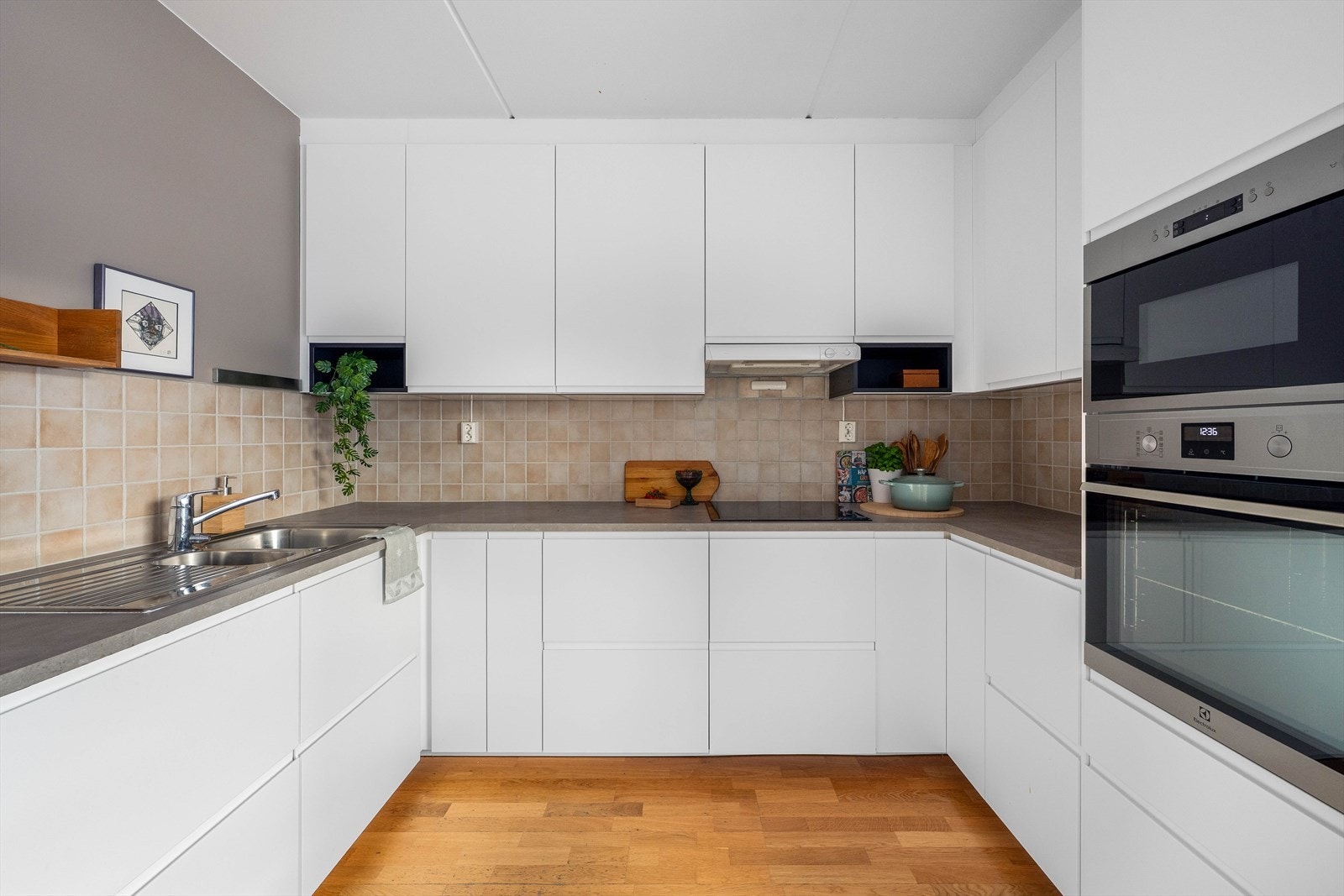 Praktisk kjøkkenventilator med avtrekk ut og fliser over benken for en elegant finish. Galleribilde