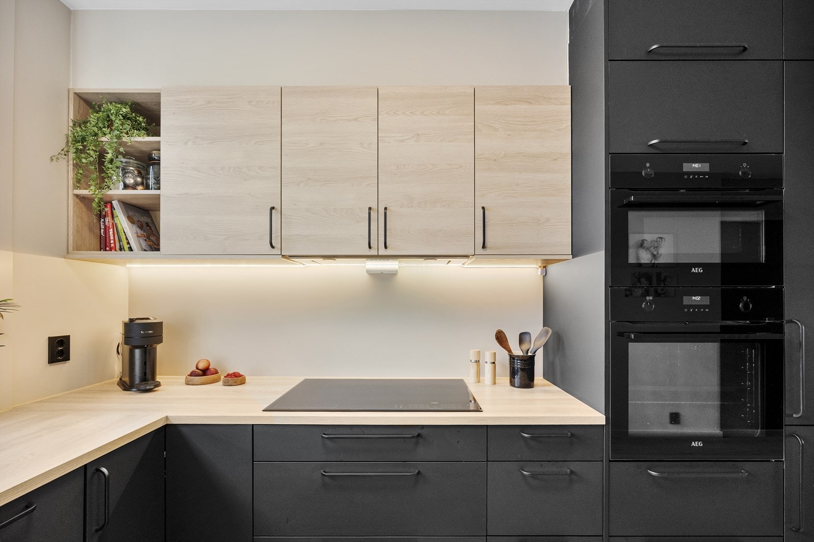 En lyslist er montert over benken, og over kokesonen har kjøkkenet en komfyrvakt og en ventilator med avtrekk ut. Alle hvitevarene er integrerte, bestående av platetopp, stekeovn, kjøleskap, fryseskap, oppvaskmaskin og mikrobølgeovn/stekeovn. Galleribilde