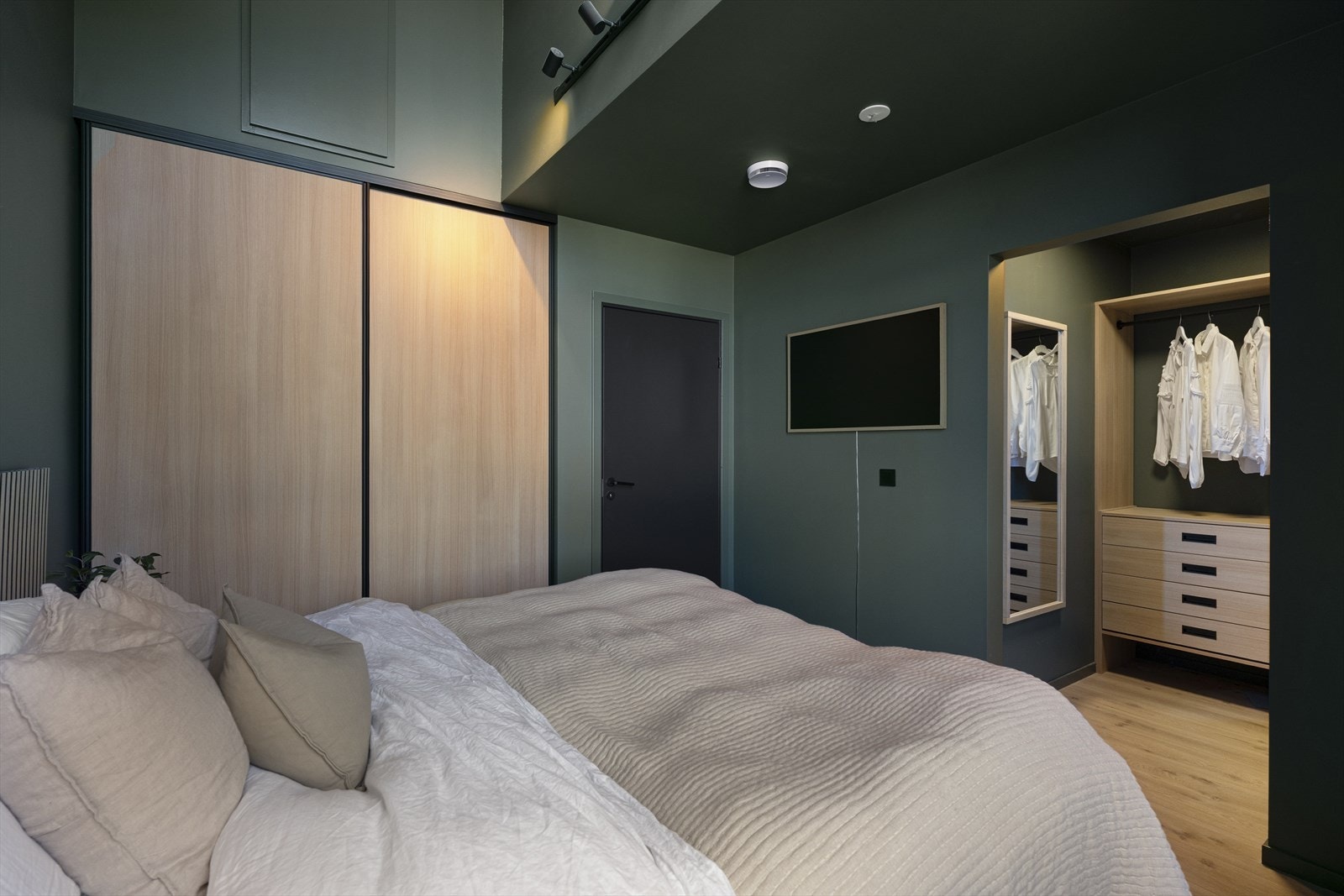Både tak og vegger er malt i en mørk grønntone, noe som gir et stilrent, men likevel lunt og avslappende uttrykk. Her får man hotellfølelsen hjemme, stor skyvedørsgarderobe og eget walk-in closet. Galleribilde