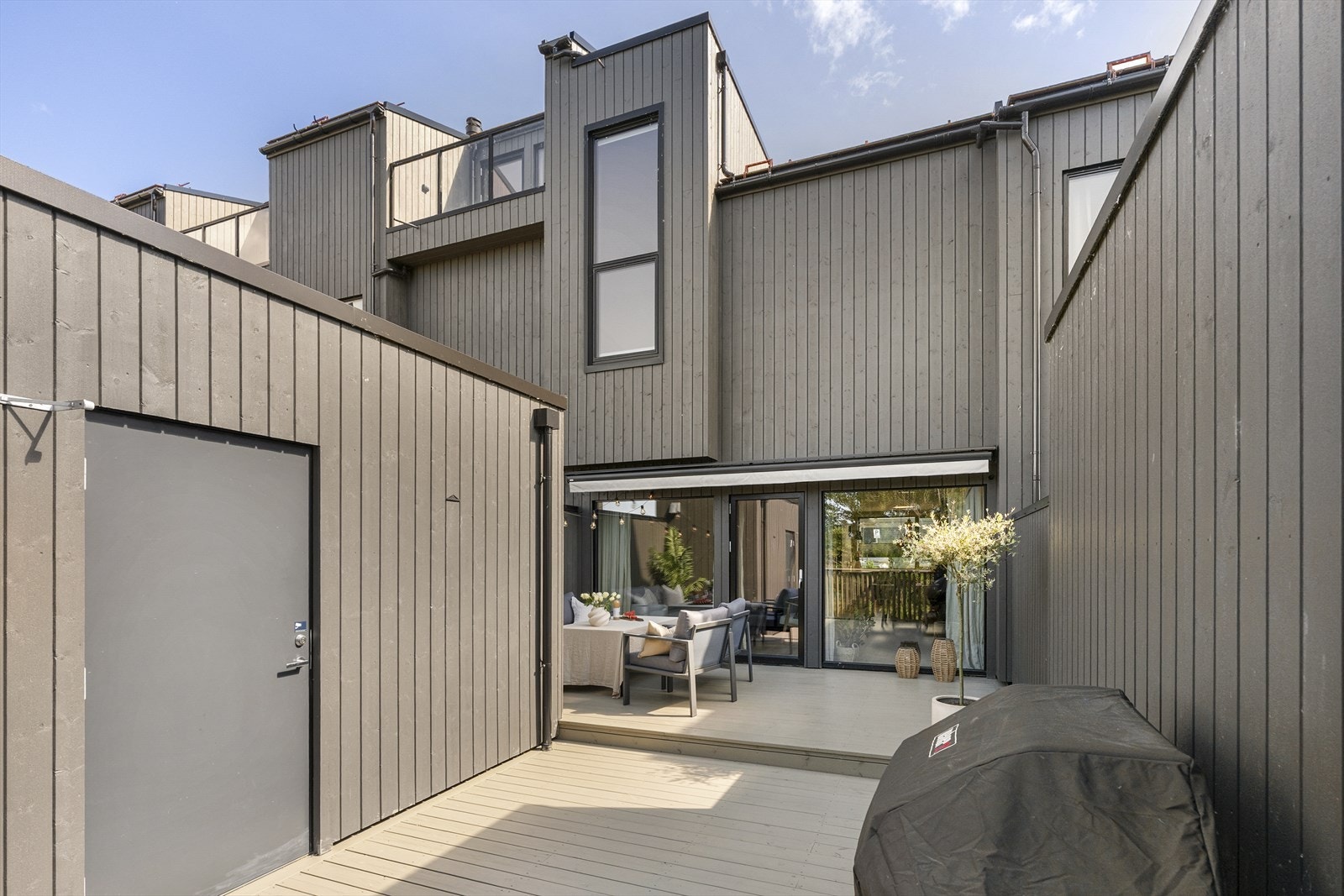 Terrassen måler ca. 33 kvm. Høye levegger bidrar til fin skjerming, og terrassen har en hendig bod og en stor markise for ekstra komfort. Uterommet innredes enkelt i ulike soner, og innbyr til både stille stunder og lange, sosiale kvelder. Galleribilde