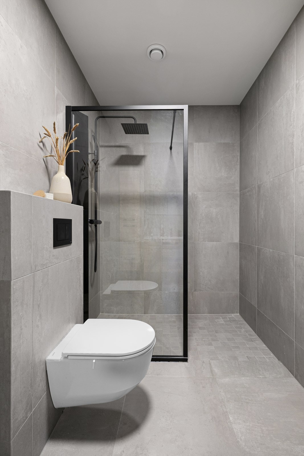 På badet er det gulvvarme og vegghengt toalett, og et romslig dusjhjørne er utstyrt med glassvegg og sort regnfallsdusj. Galleribilde