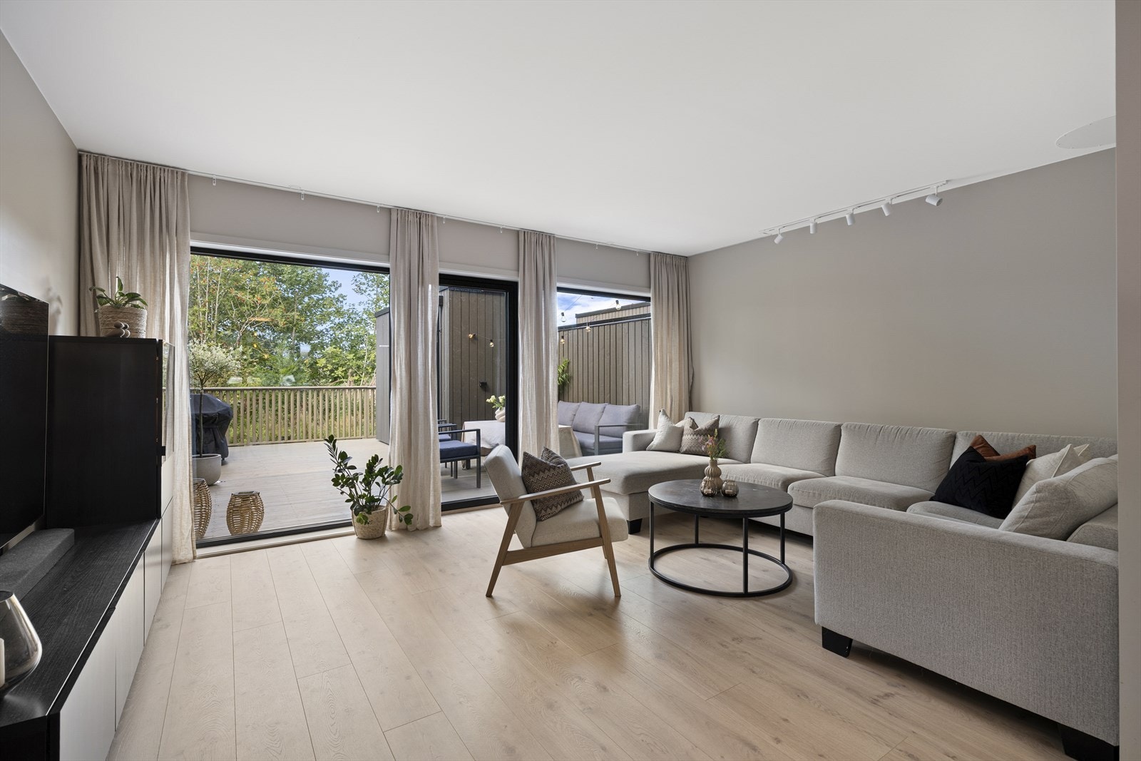 Sammen utgjør stuen og kjøkkenet et åpent allrom, med flott gjennomlys via store vinduer på begge sider av rommet. Innerst går vinduene til gulvet, inkludert en glassdør til den herlige terrassen. Galleribilde