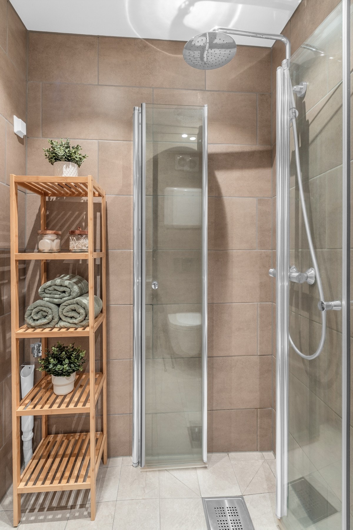 Bad/vaskerom med veggmontert toalett, dusjdører i herdet glass, speilskap, opplegg for
vaskemaskin, baderomsinnredning med høyglans fronter og heldekkende servant. Galleribilde