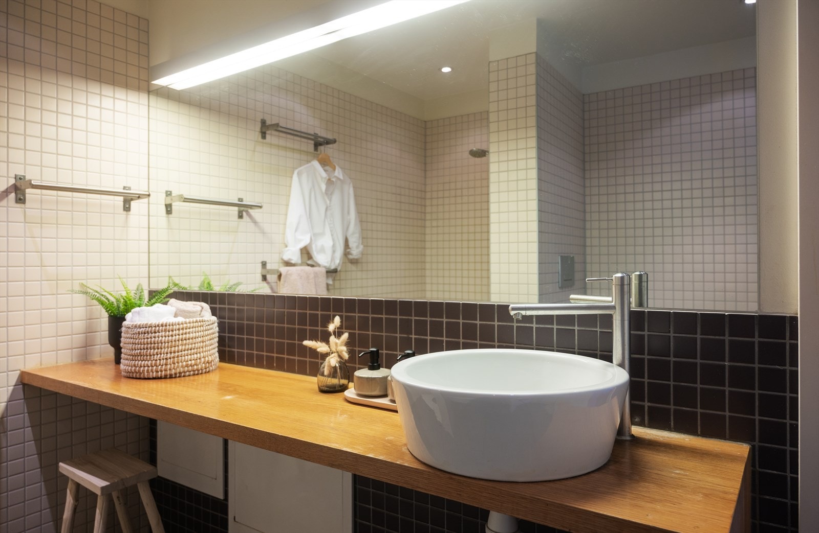 Baderomsinnredning i eik med heldekkende servant og stort speil med belysning. Galleribilde