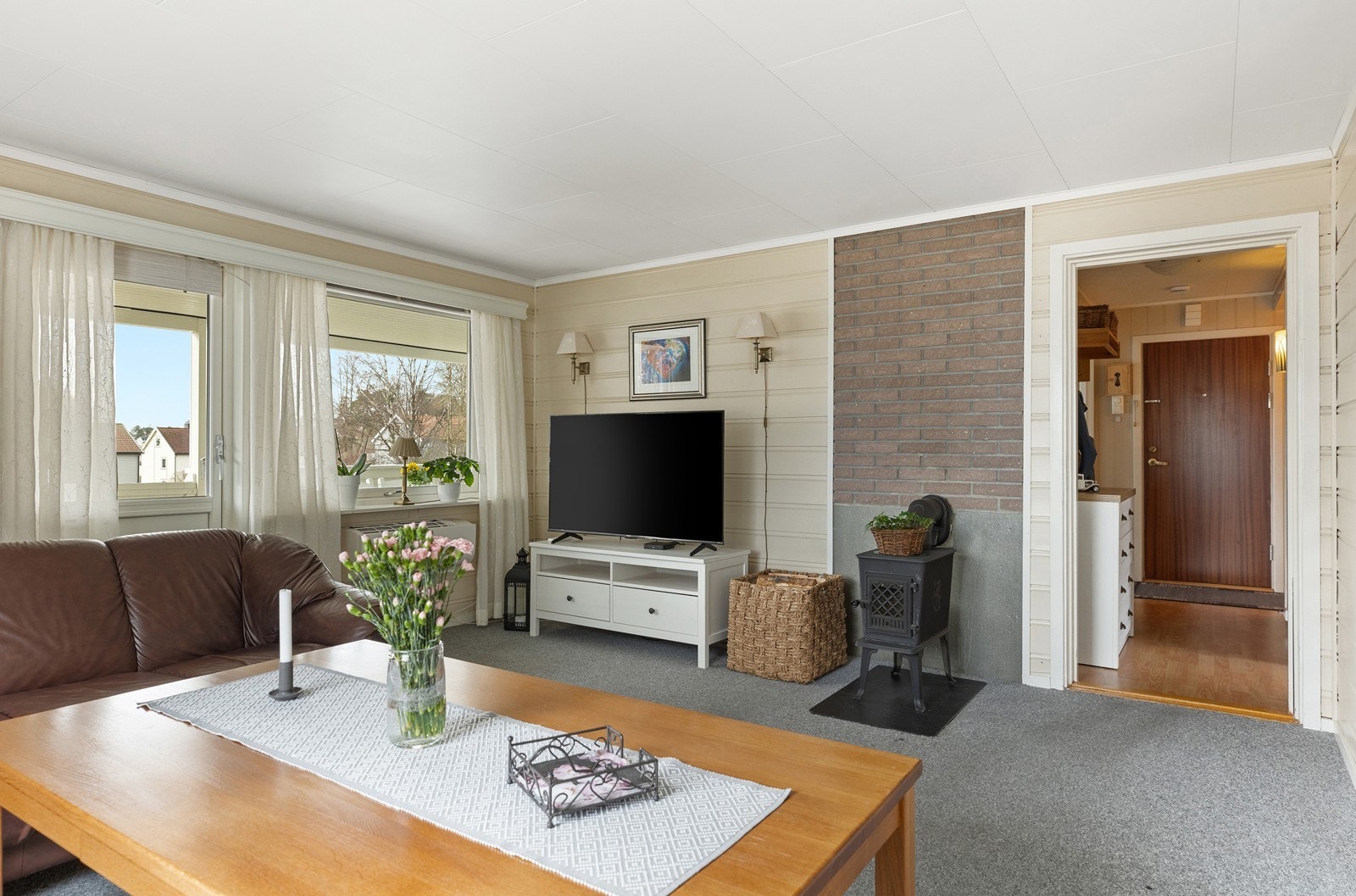 Stor stue med vedovn og utgang til solfylt veranda. Galleribilde