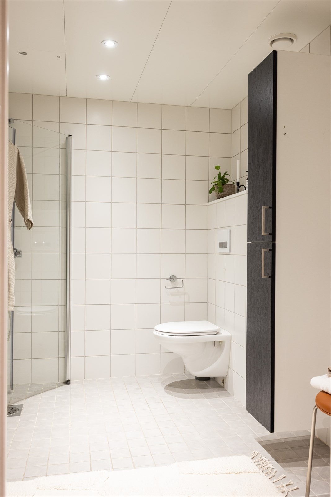 Badet inneholder veggmontert toalett, servant med innredning og dusjnisje med glassdører. Opplegg til vaskemaskin. Galleribilde