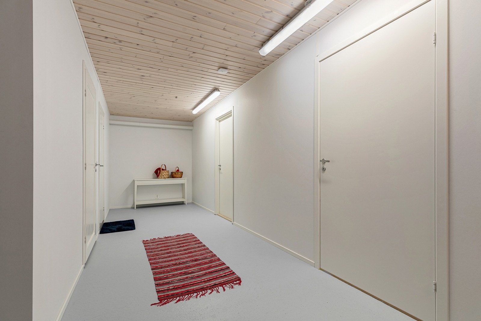 Gang i kjeller. Dør til venstre er inn til stort uinnredet kjellerrom. Dør lengst innerst er til kontor/sov og dør til høyre er til hoveddel Galleribilde