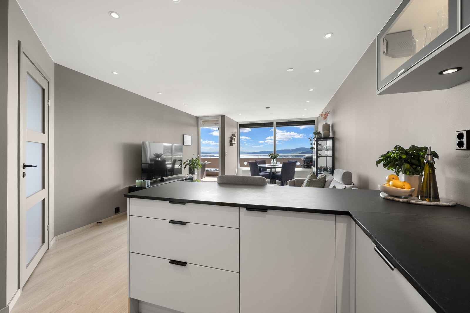 Åpen kjøkken- og stueløsning med store vindusflater som gir mye lys samt utsikt Galleribilde