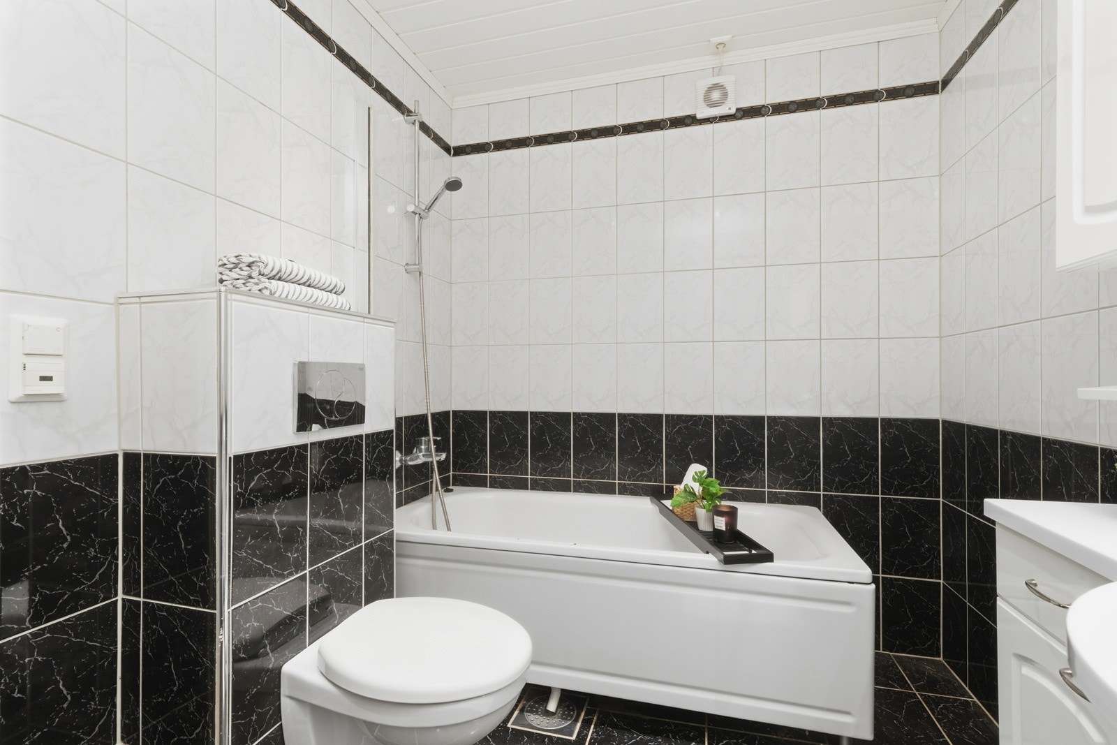 Badet er innredet med klosett, badekar og servant over servantskap med profilert utførelse. Galleribilde