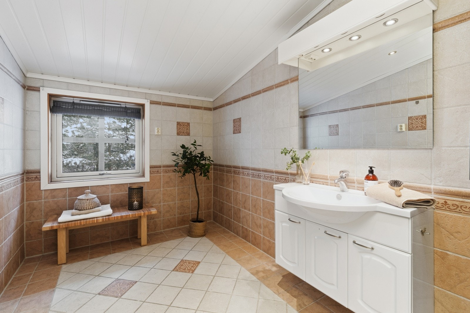 Badet har varme i gulv og er innredet med servant over servantskap, kloset og dusjkabinett. Galleribilde