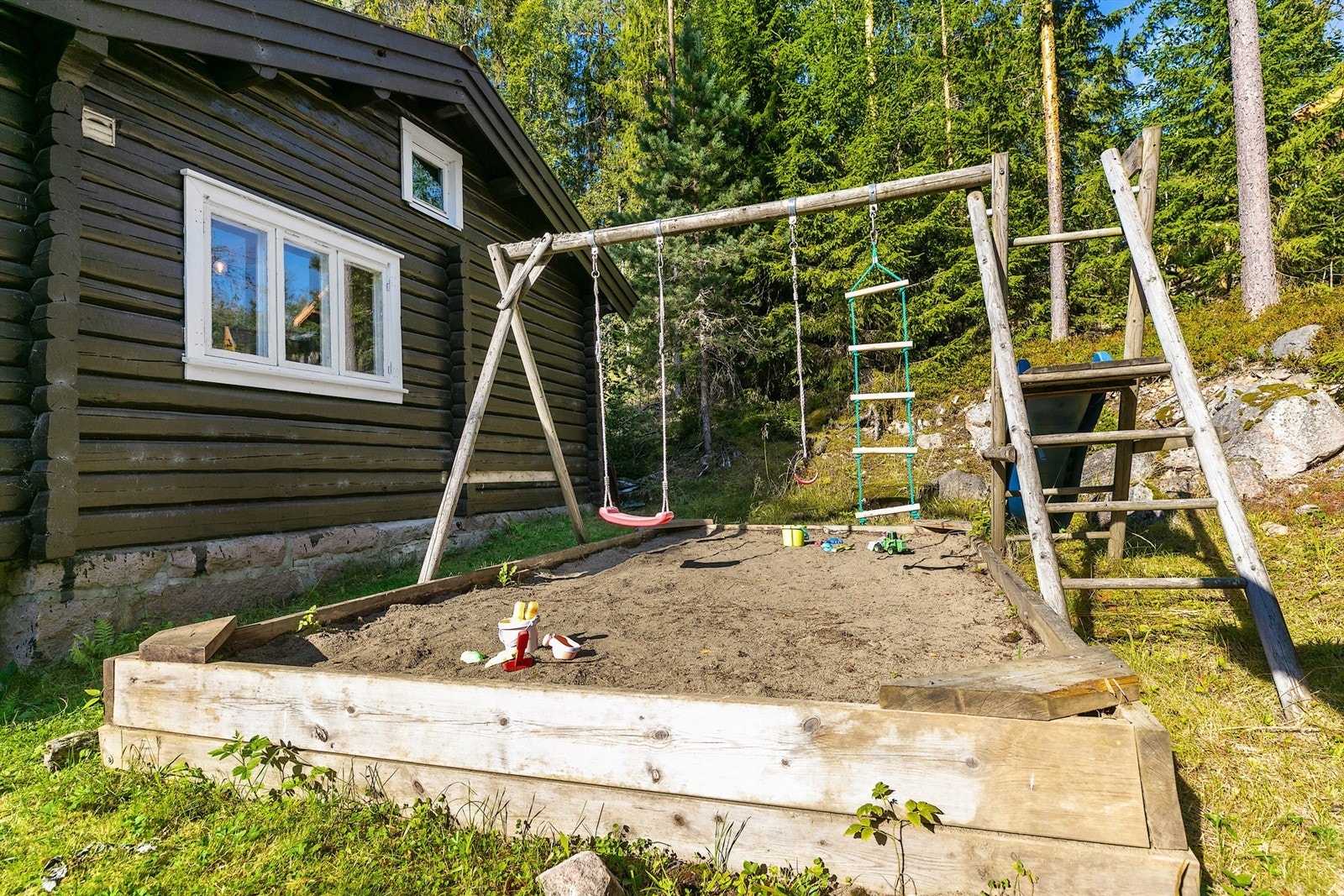 Barnevennlig uteområde med sandkasse, huskestativ og en koselig lekestue som gir små og store mange timer med glede Galleribilde