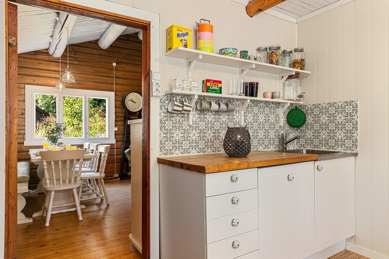 Rett utenfor kjøkkenet ligger en hyggelig spiseplass med vinduer som gir godt lys og fin utsikt til naturen Galleribilde