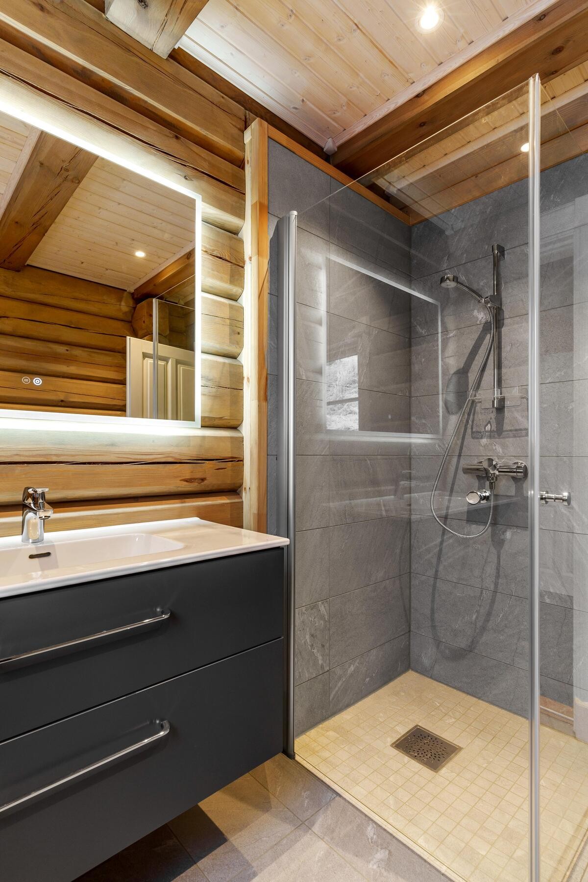 Badet er innredet med servantskap, dusjhjørne og toalett. Galleribilde