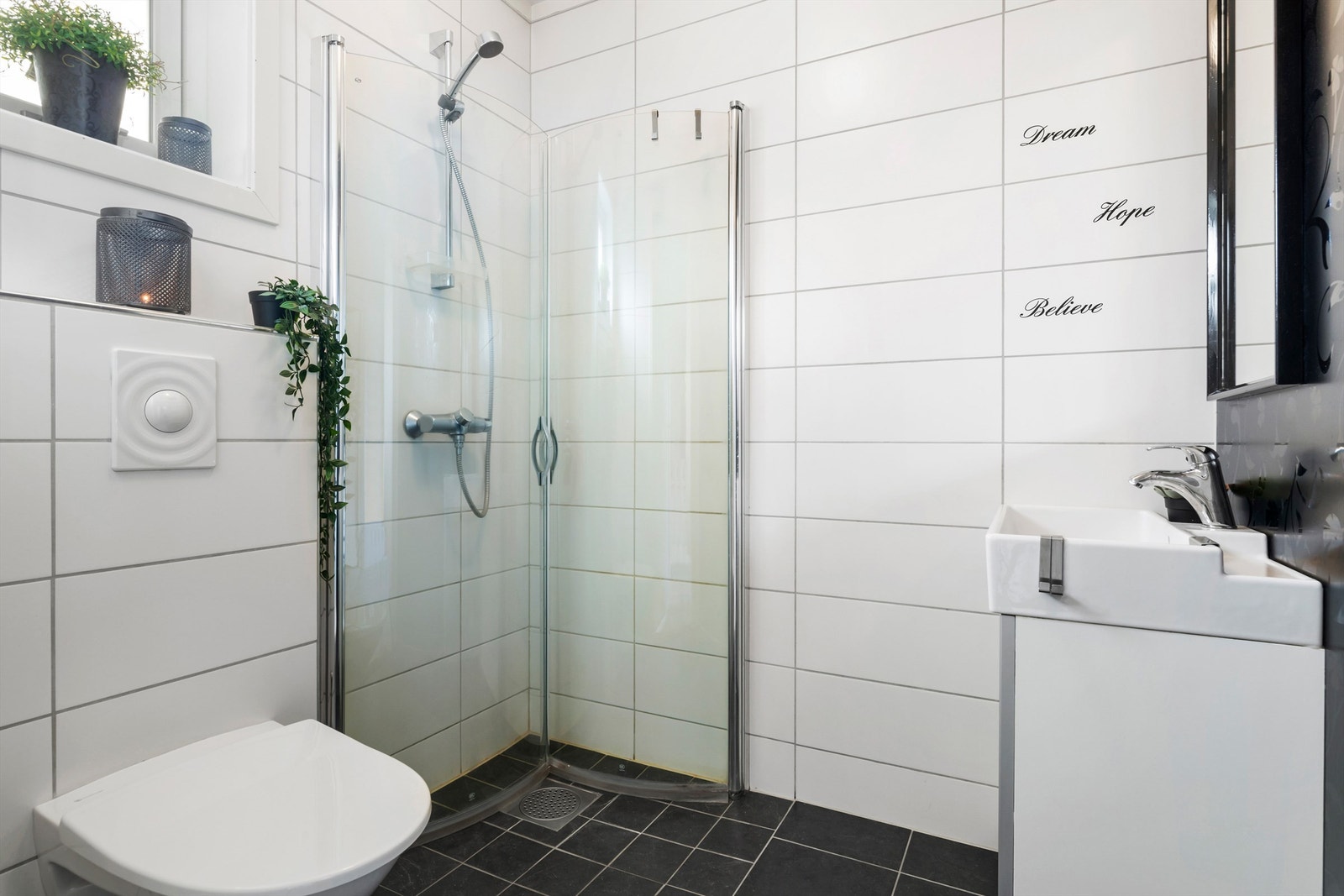 Boligen er praktisk inndelt med to fullverdige bad- ett i hver etasje. Badet i hoved/2. etasje er tidløst og har vegghengt toalett og dusjhjørne med plassbesparende foldedører Galleribilde