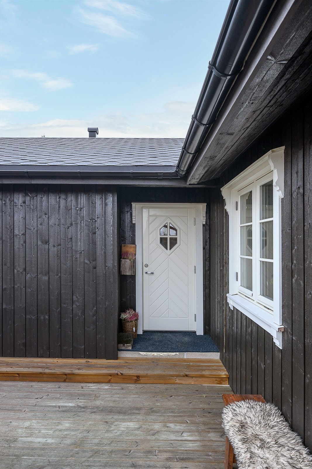 Den romslige terrassen går på 2 sider av hytta og er en del av inngangspartiet. Et lite overbygg over inngangsdøra. Galleribilde