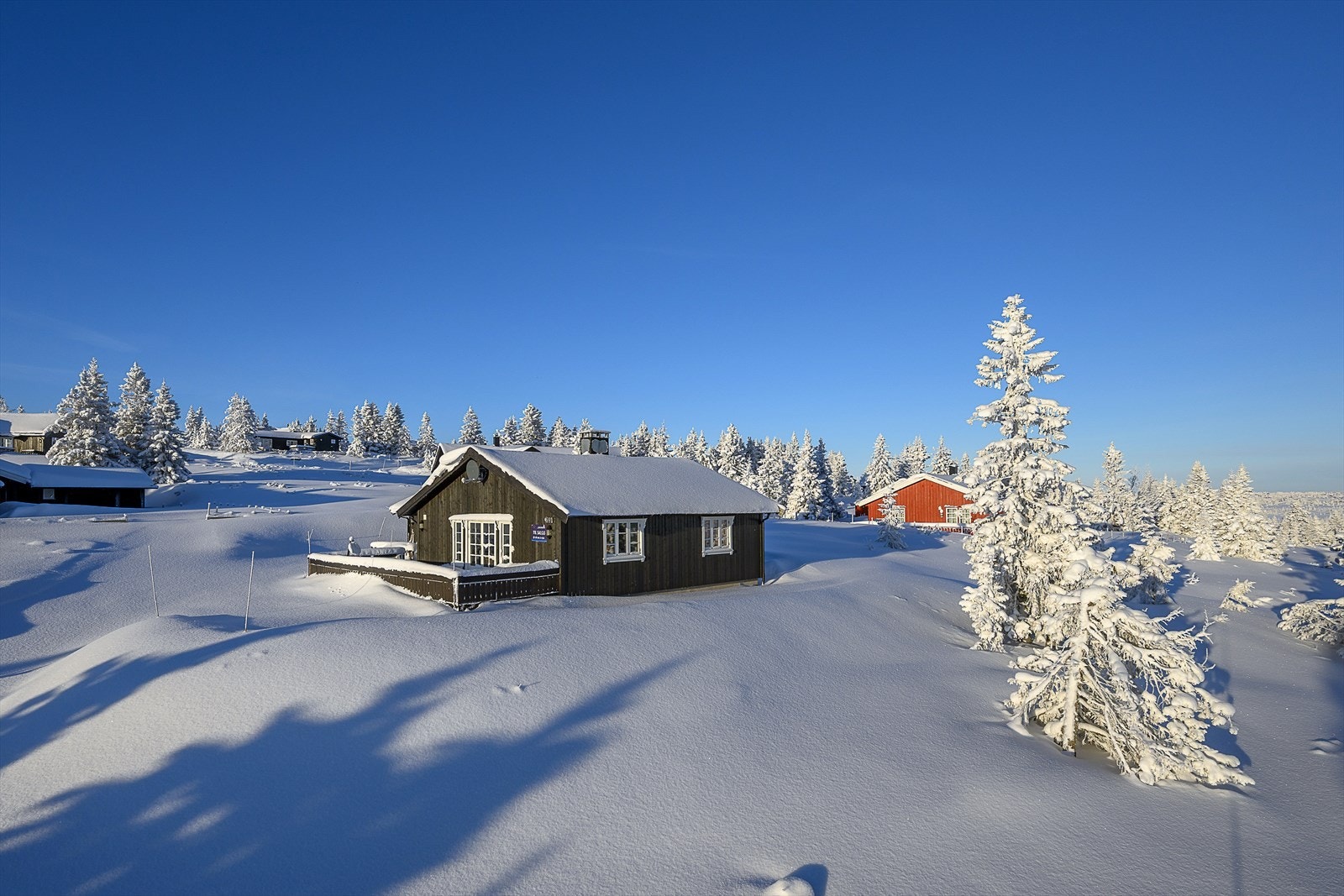 Den romslige terrassen går på 2 sider av hytta og er en del av inngangspartiet. Et lite overbygg over inngangsdøra. Galleribilde