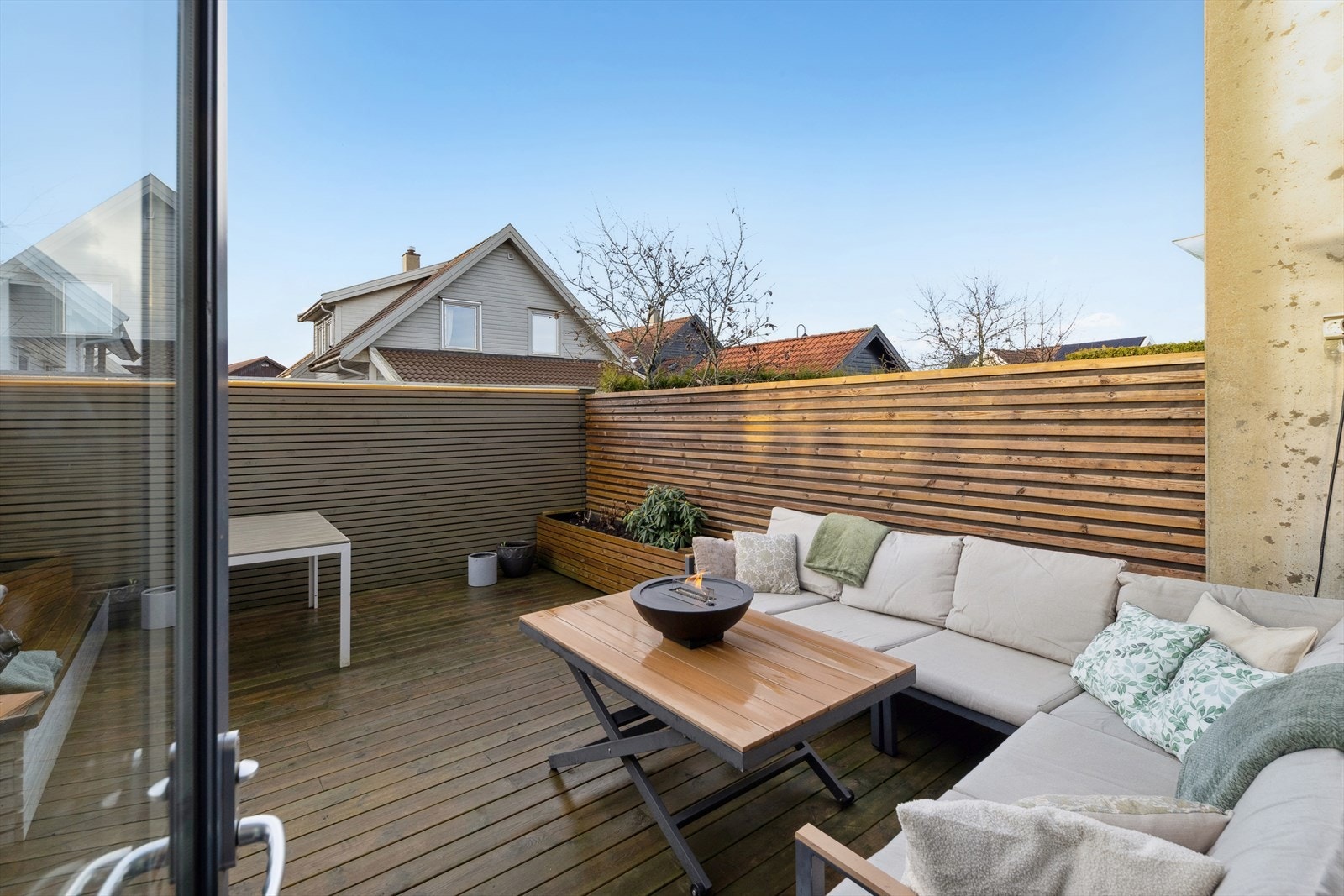 Boligen har også en stor, inngjerdet terrasse som ligger vestvendt til og som er flott opparbeidet med plantekasser og sittebenk. Her har man god plass til å møblere med sittegrupper og grill. Galleribilde