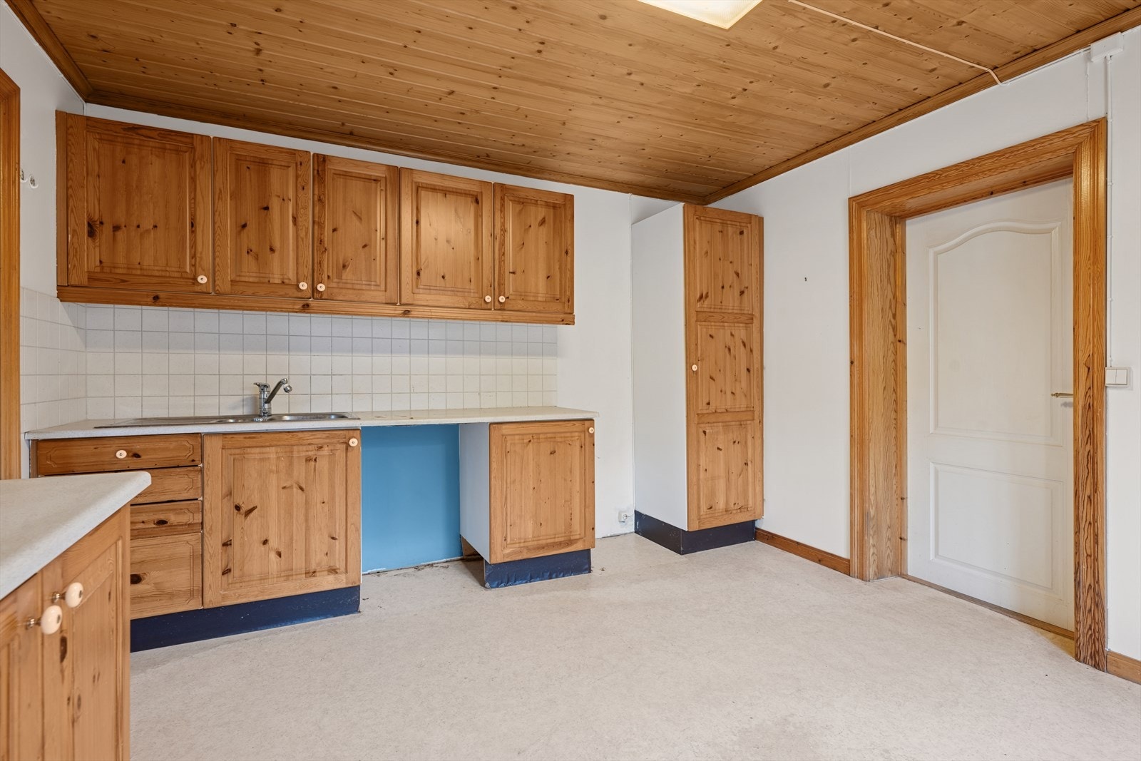 Kjøkkenet har innredning med profilerte fronter, benkeplaten er av laminat. Veggen mellom overskap og benkeplaten er flislagt. Det er kjøl/fryseskap, oppvaskmaskin og komfyr. Galleribilde