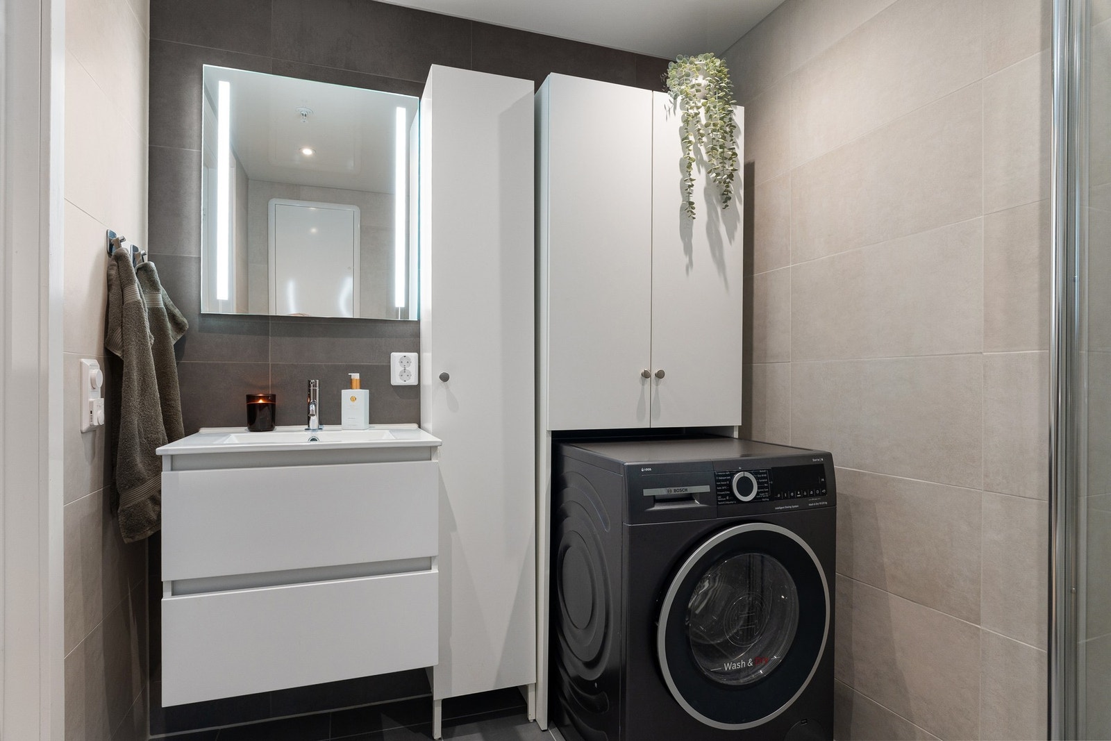 Flislagt gulv med gulvvarme og flislagte vegger. Malt himlingsflate med downlights. Servant med armatur og speil. Galleribilde