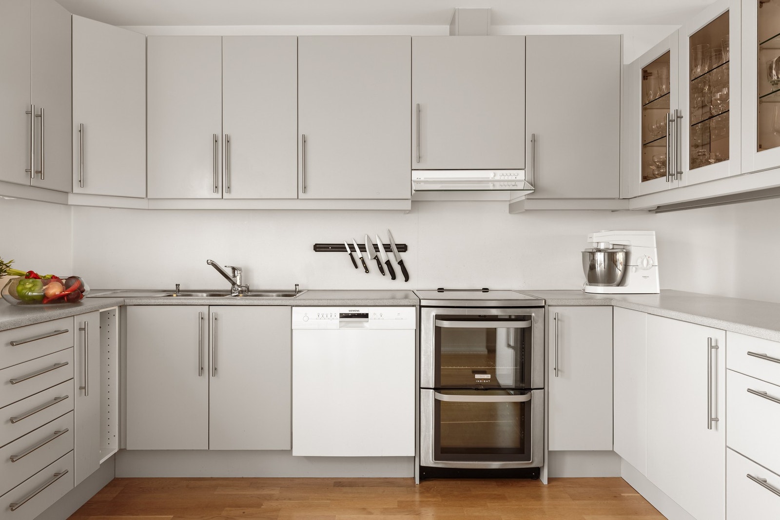 Løsningen består av laminat benkeplate og hvitevarer som oppvaskmaskin, ventilator og frittstående komfyr. Galleribilde