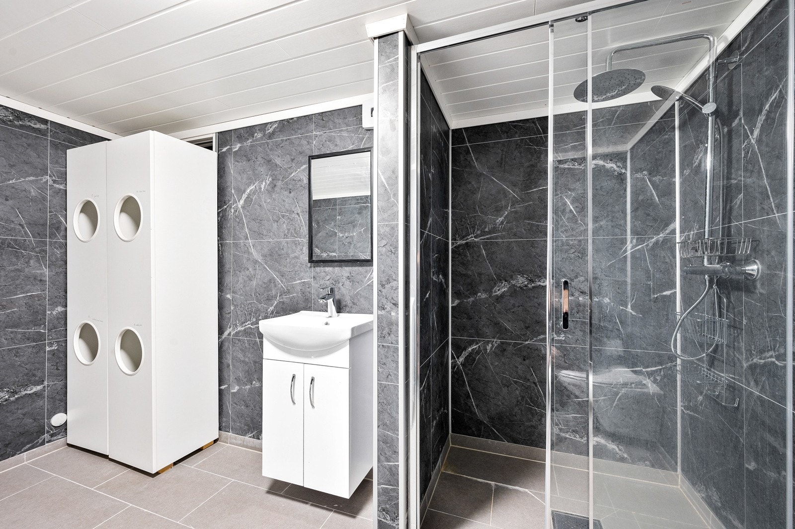 Bad med vaskeromsløsning innredet i 2021. Her er det flislagt gulv med gulvvarme og dusjnisje i god størrelse. Galleribilde