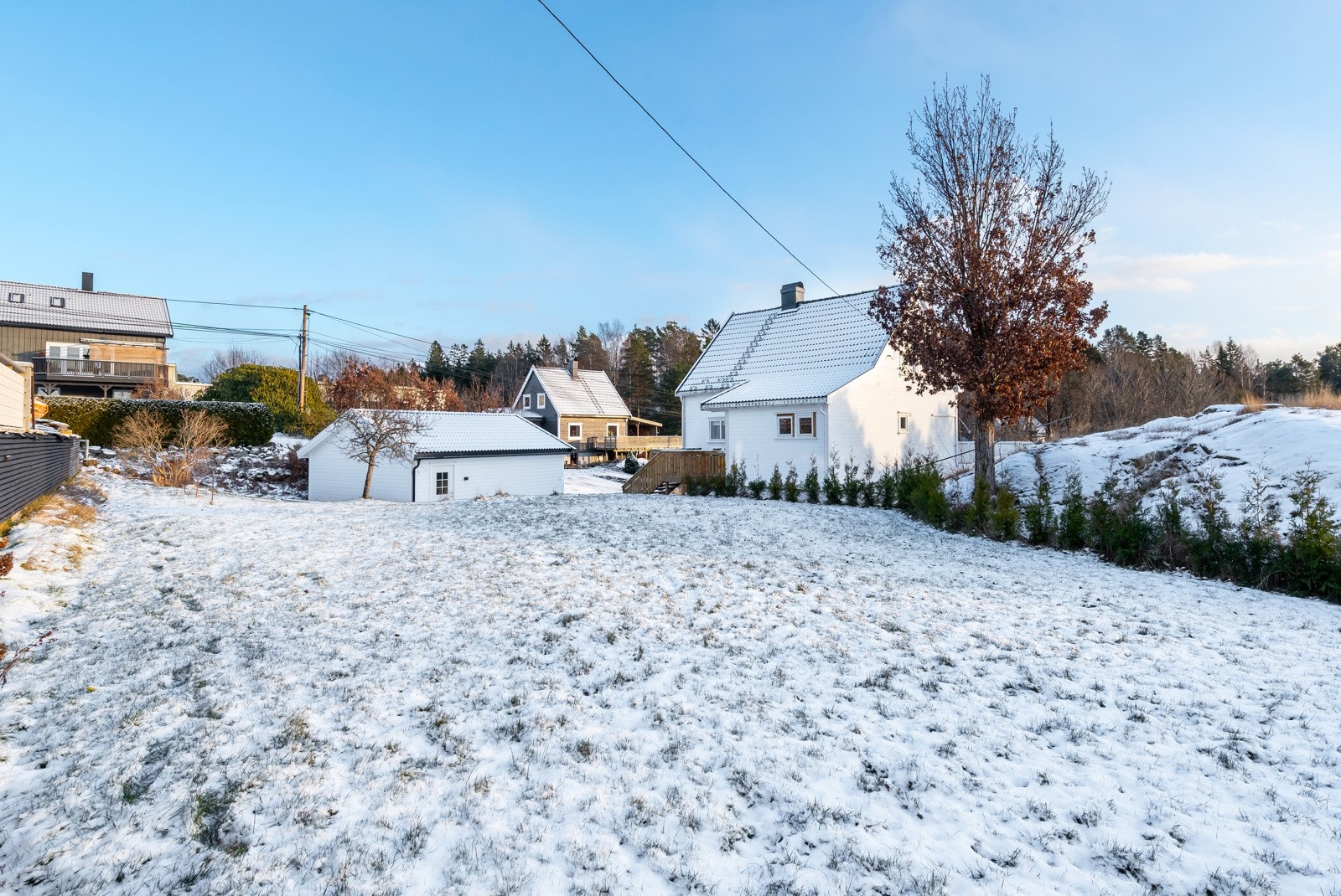Tomten er pent opparbeidet med plenarel, hekk og prydbusker, terrasser, og gruset innkjørsel. Galleribilde