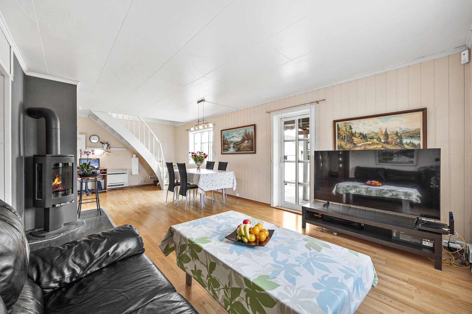 Stuen byr på en åpen og innbydende atmosfære med naturlig lys fra flere vinduer. Galleribilde