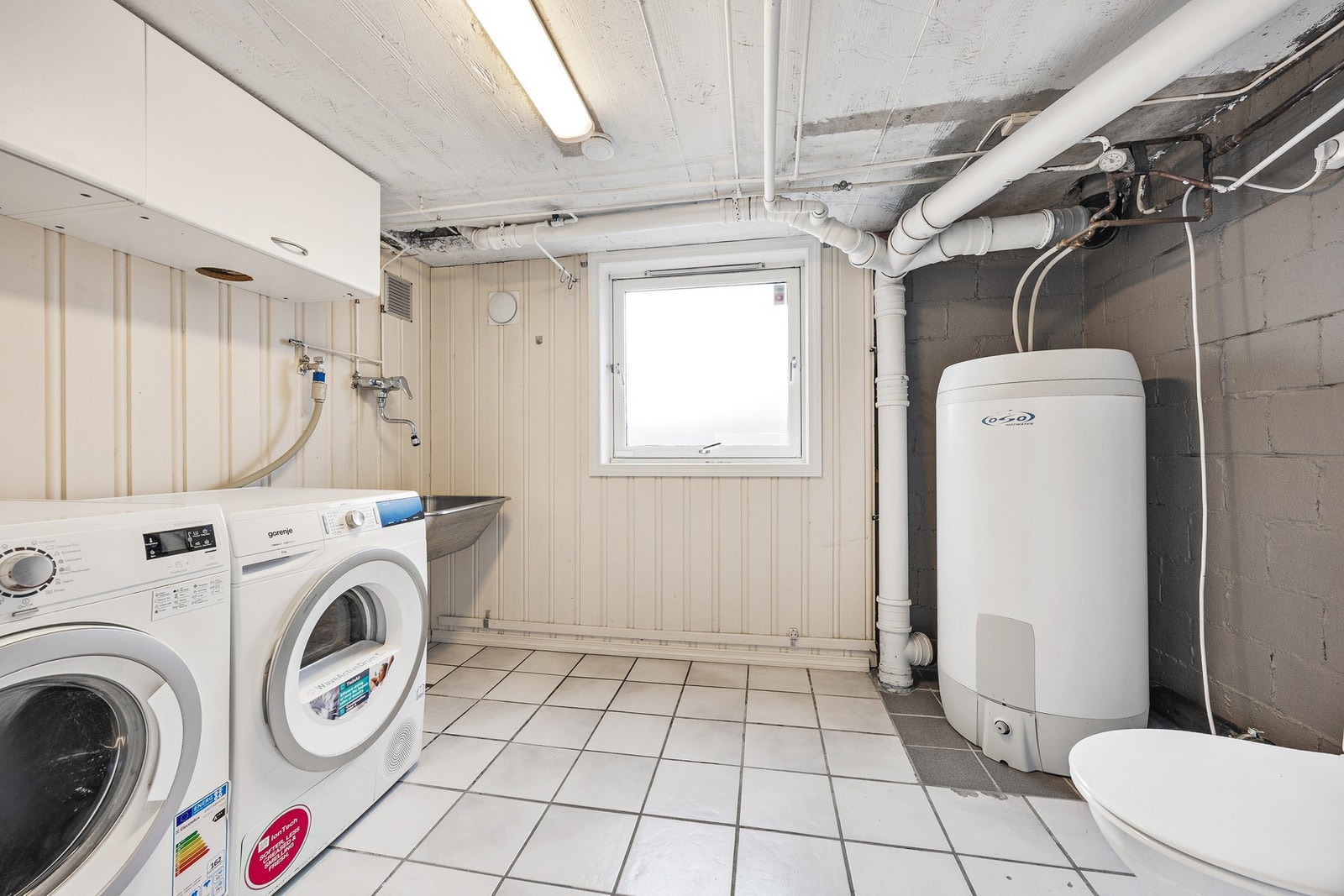 Vindu slipper inn dagslys og gir vaskerommet en lys atmosfære. Galleribilde